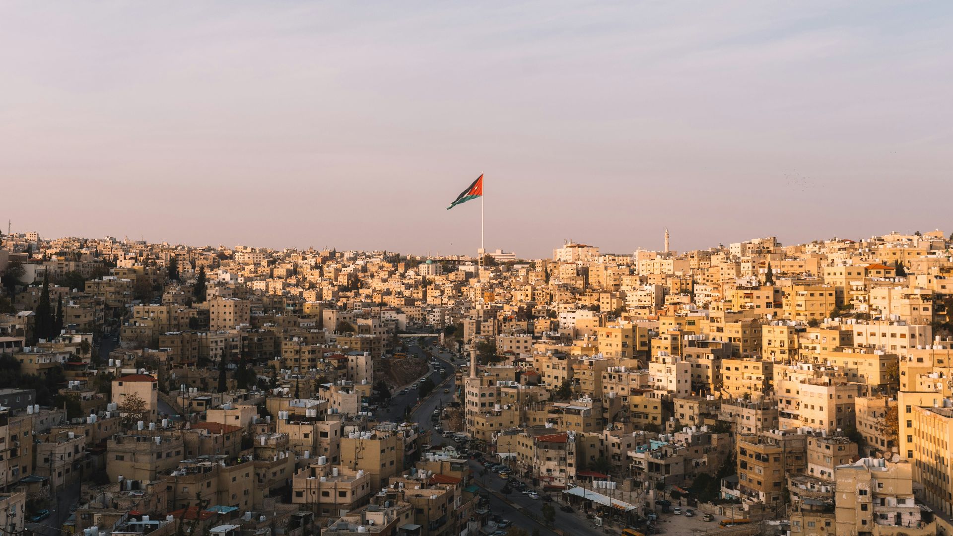 Amman cityscape with jordanian flag flying high