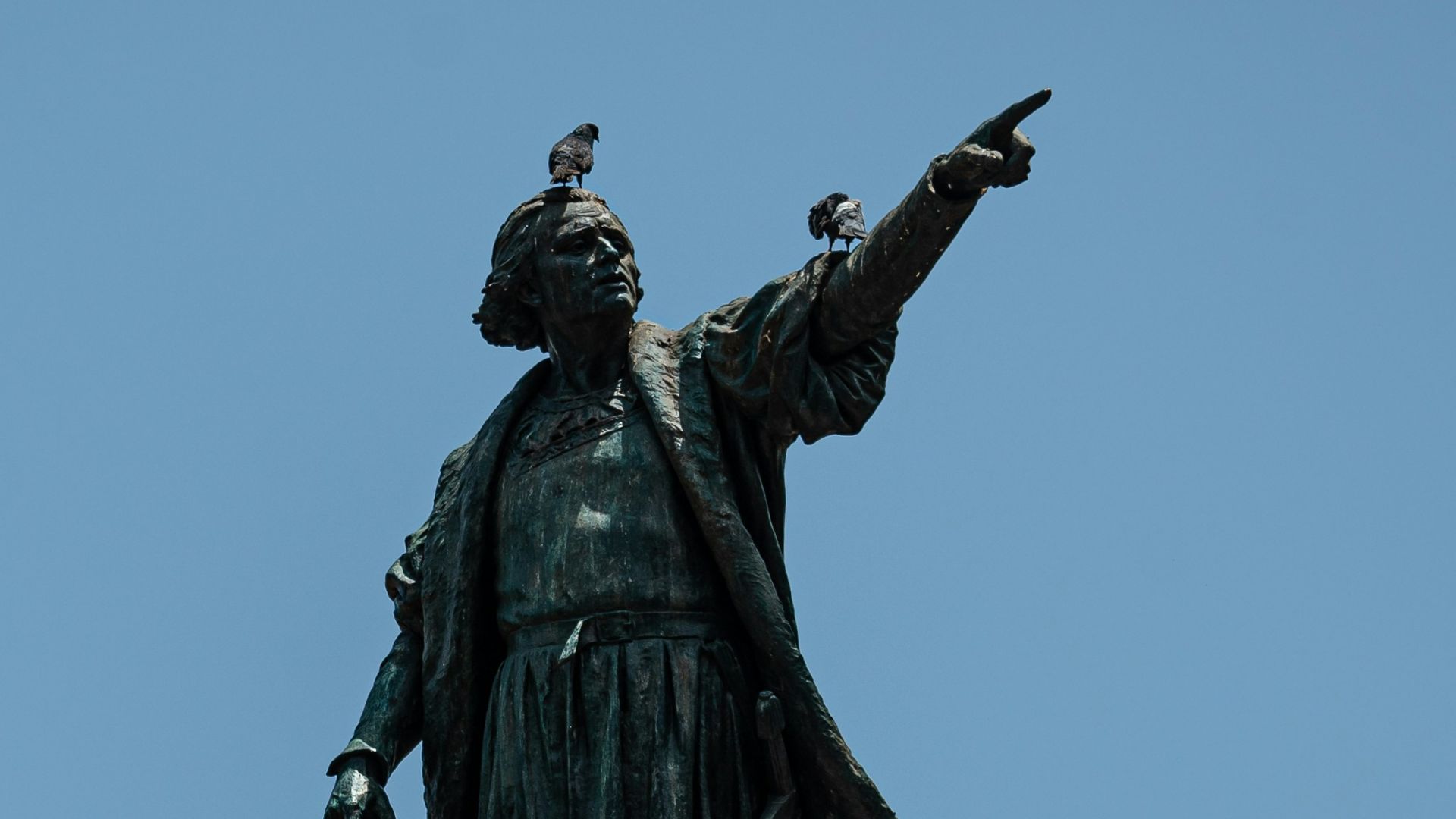 black statue of man holding yellow umbrella