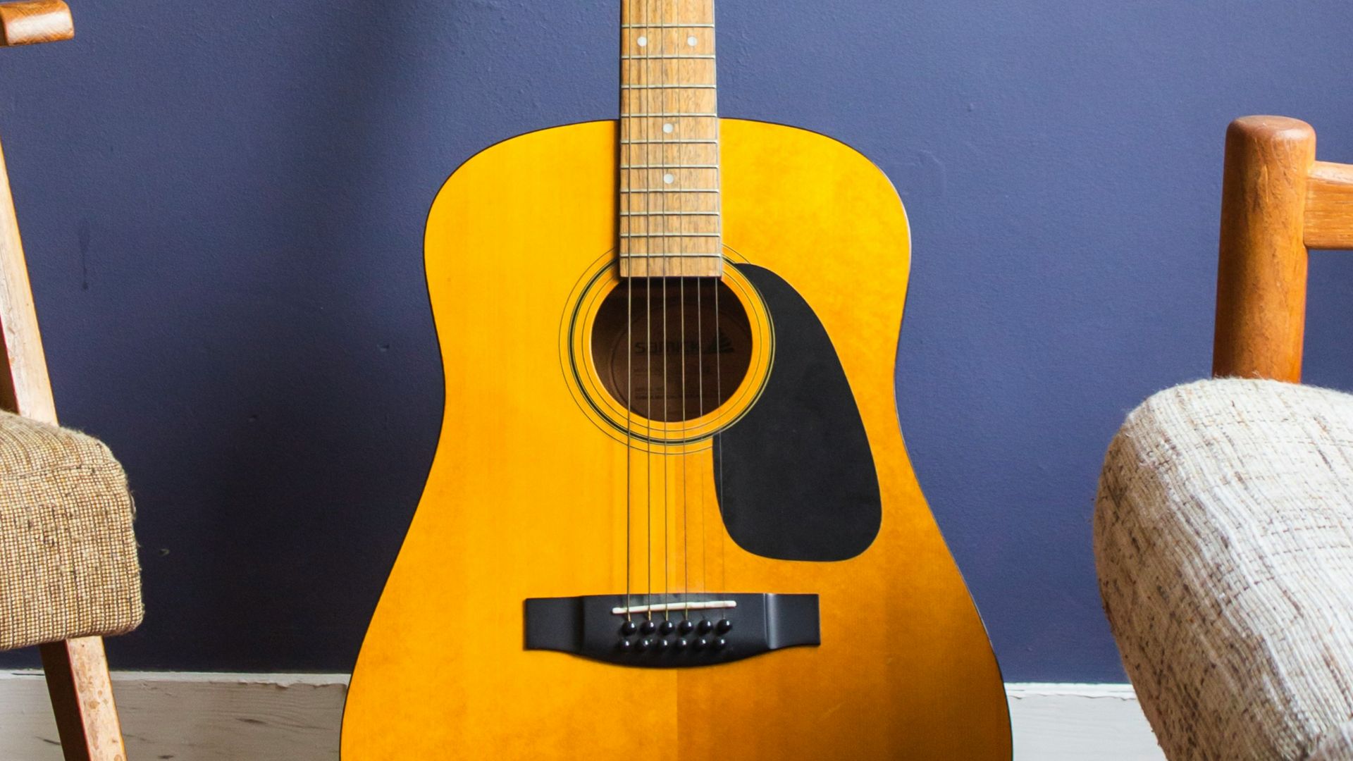 yellow acoustic guitar leaning on wall