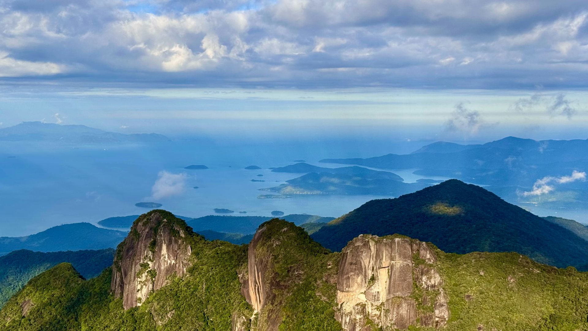 Mountain peaks overlook the vast ocean and islands.