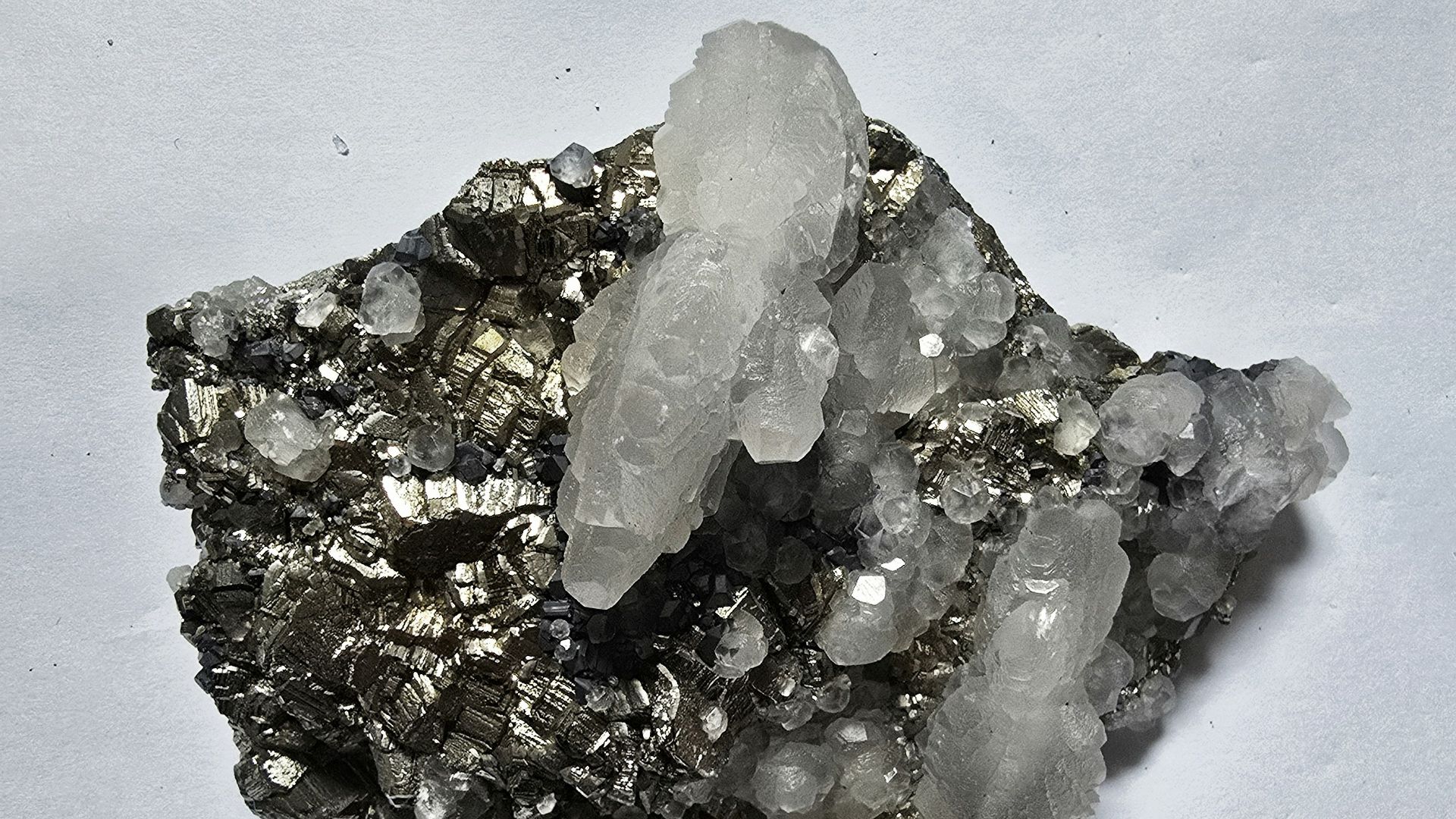 Clear quartz crystals on dark metallic mineral matrix