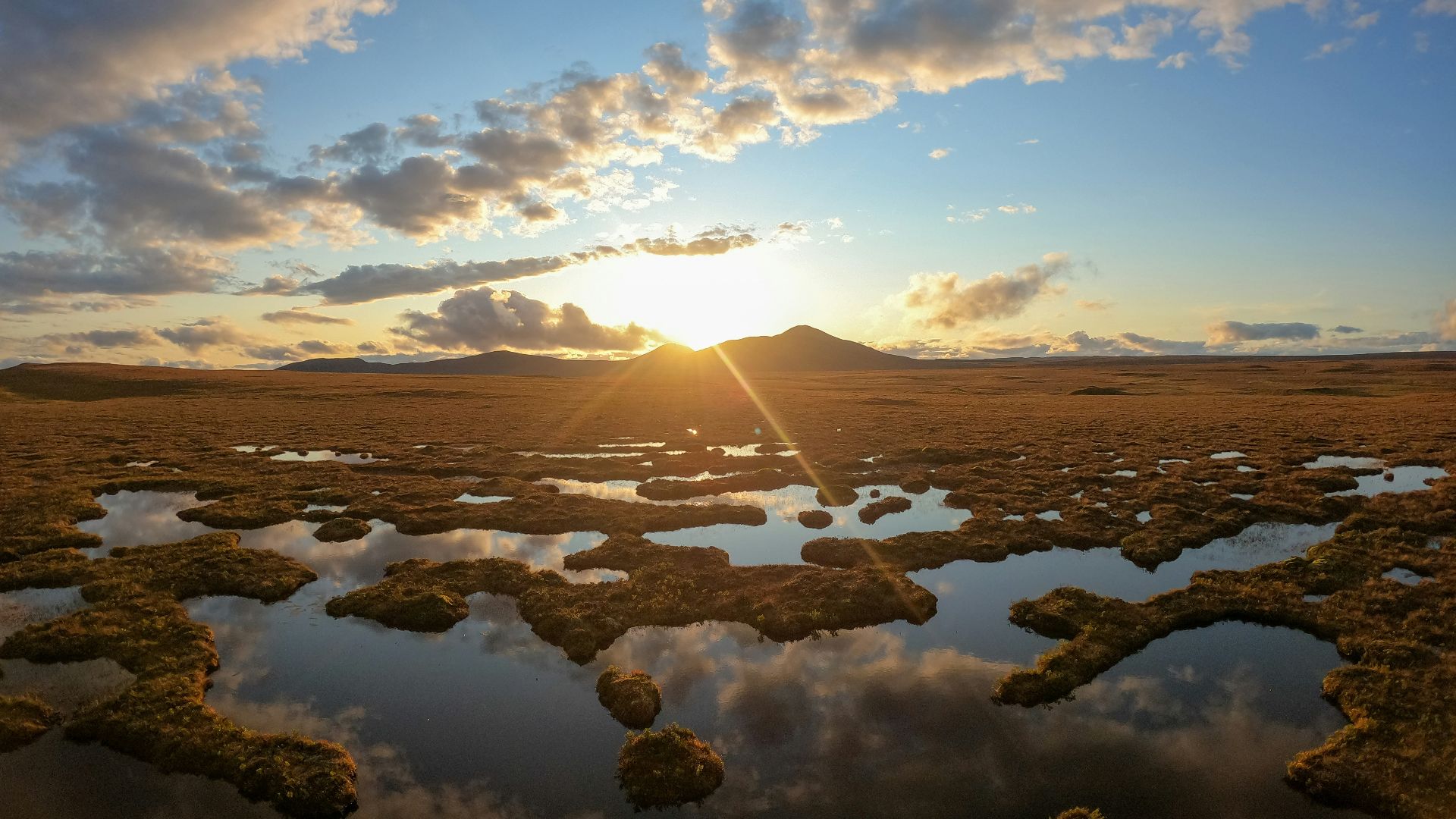 the sun is setting over a vast expanse of water