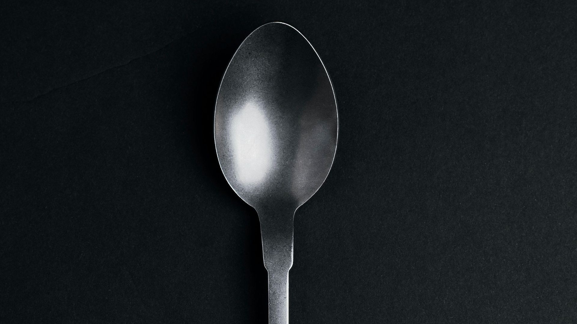 silver spoon on black textile