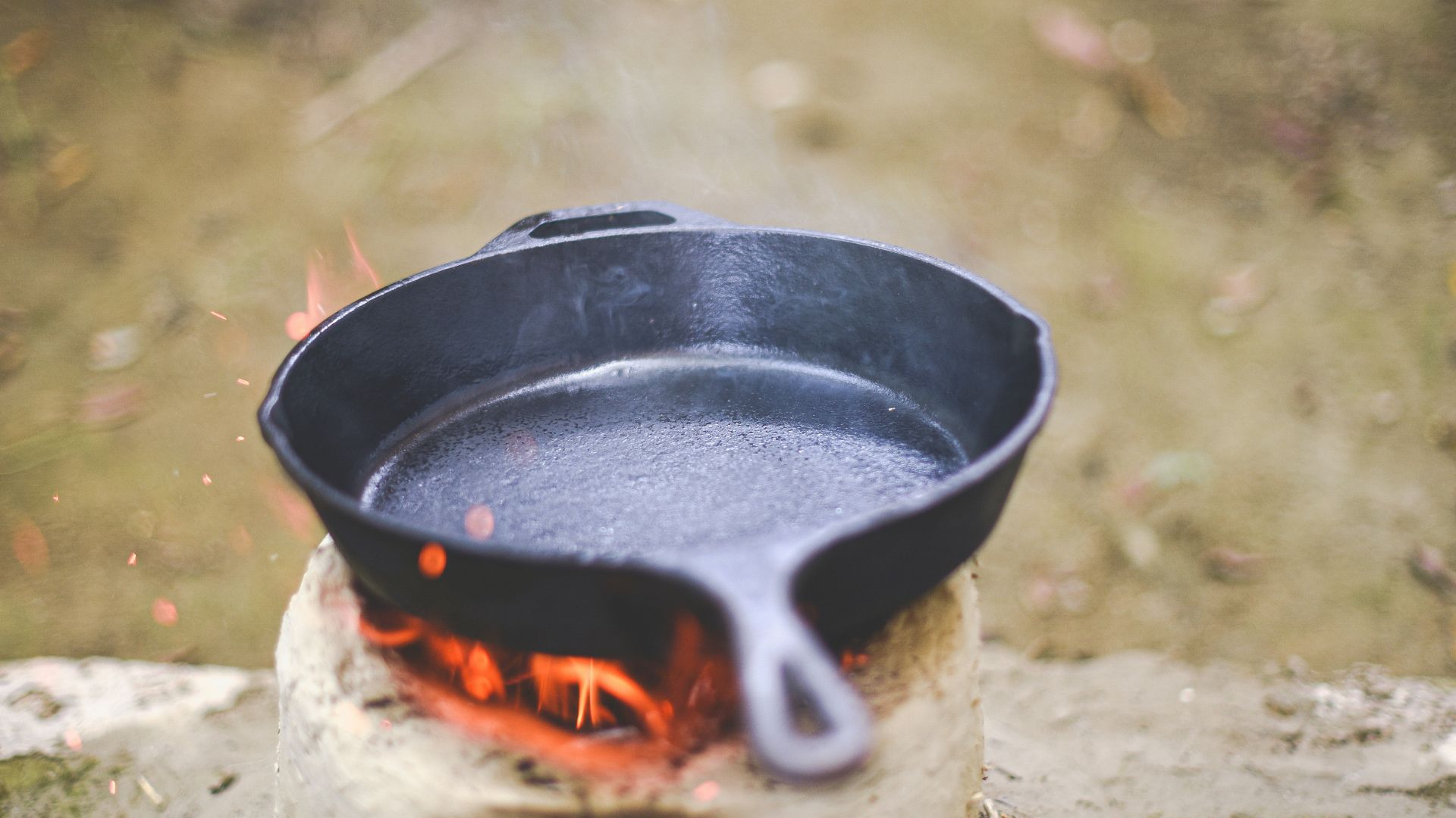 a cast iron skillet sitting on top of a fire pit