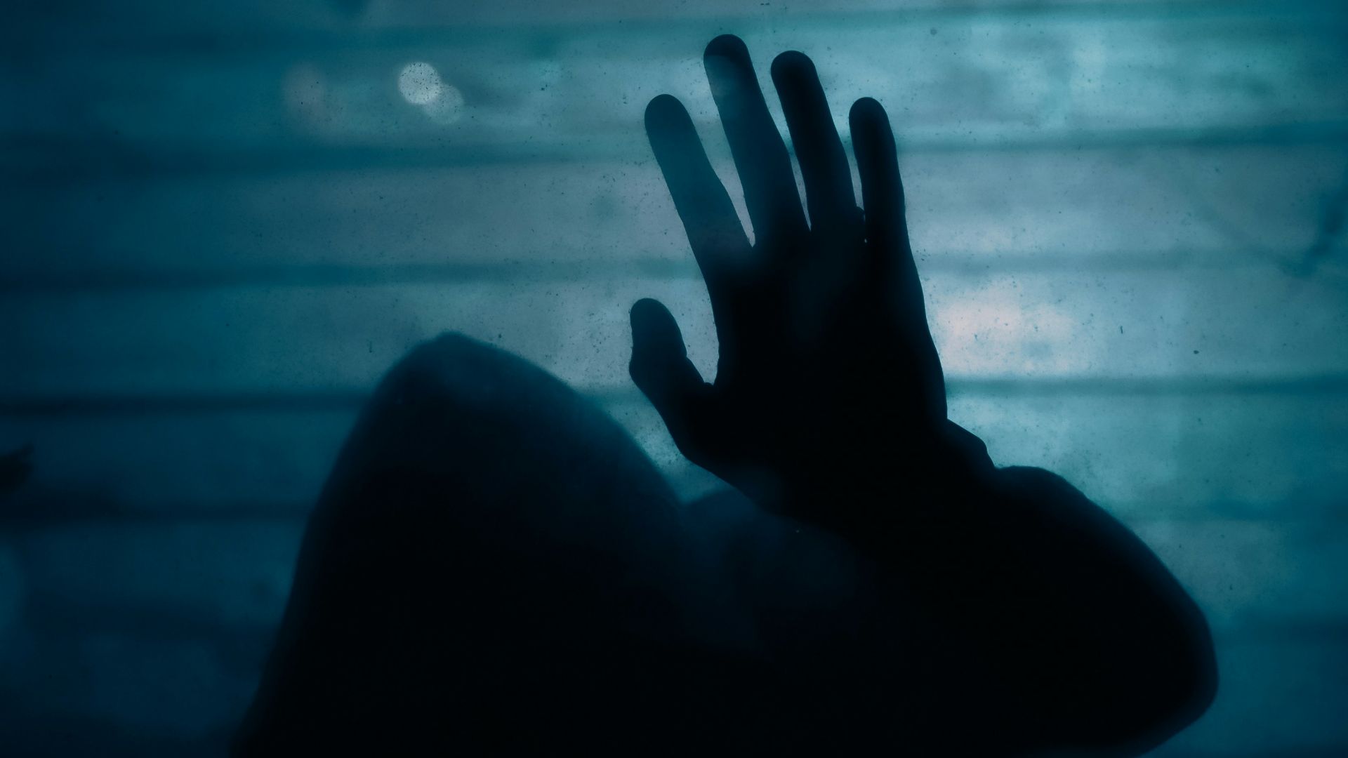 a silhouette of a hand reaching up into the air