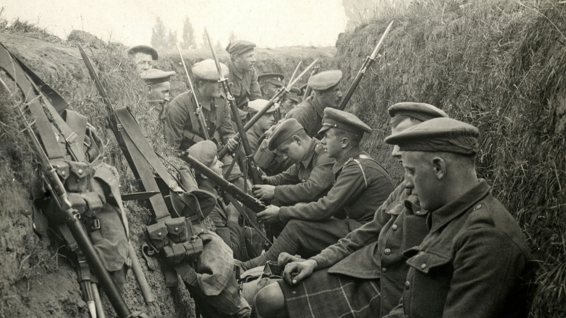 a group of men sitting next to each other in a trench