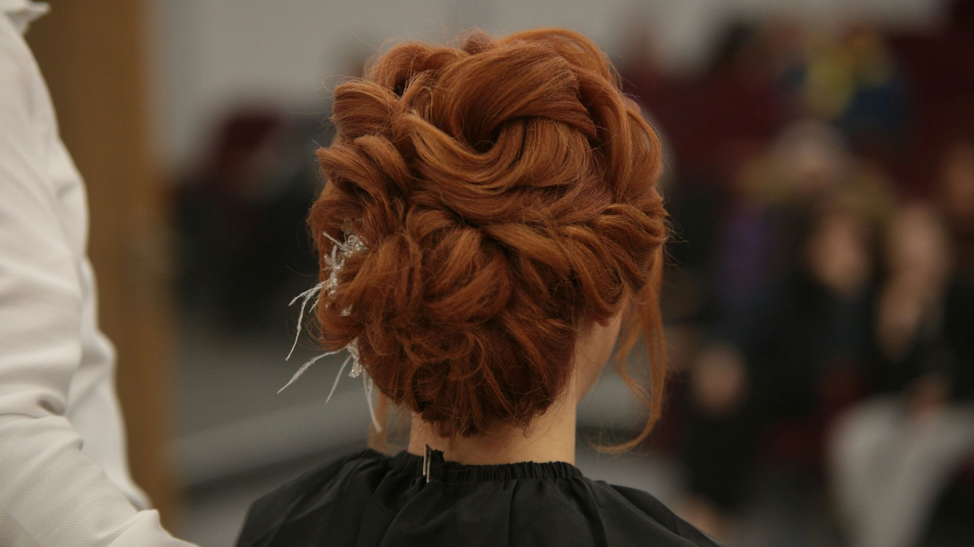 a woman with red hair is getting her hair done