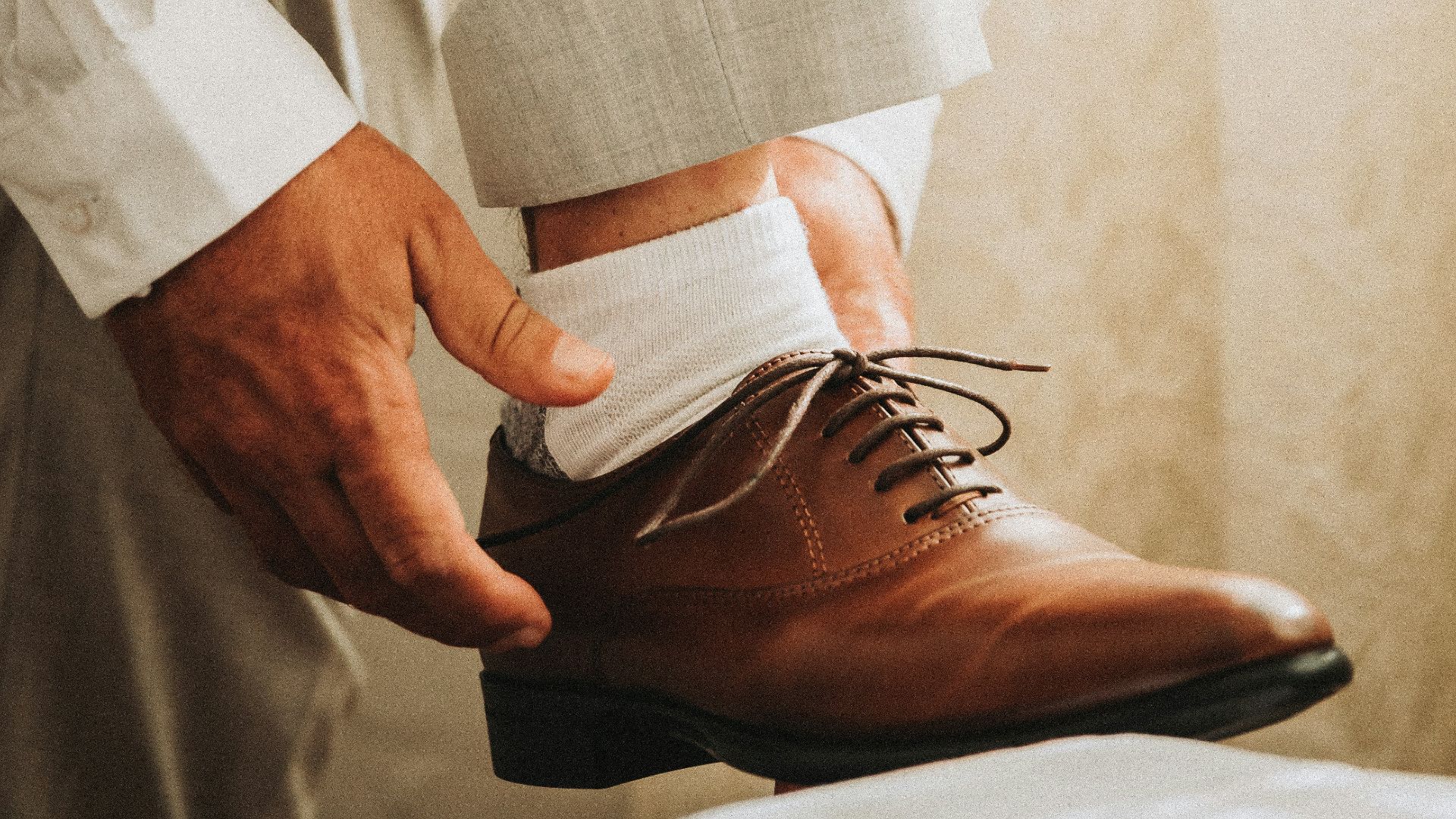 person in gray formal suit jacket wearing brown leather shoes