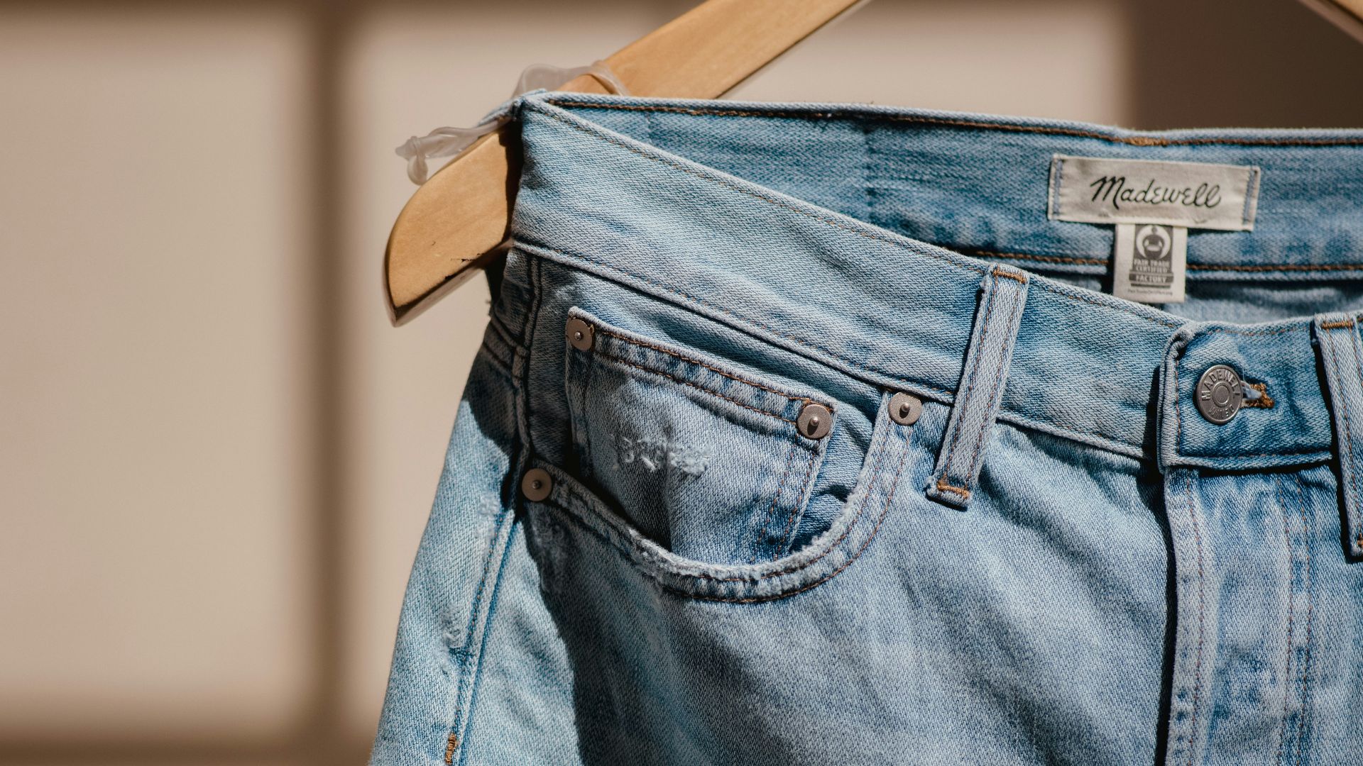 blue denim jeans on brown clothes hanger