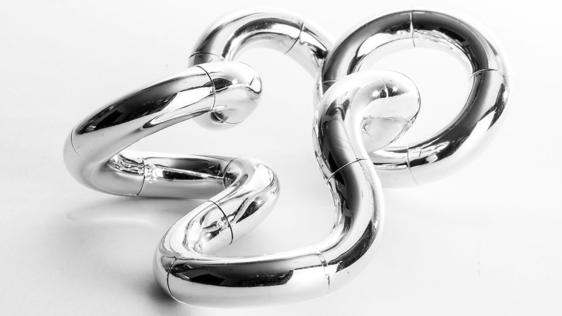 a shiny metal object on a white surface