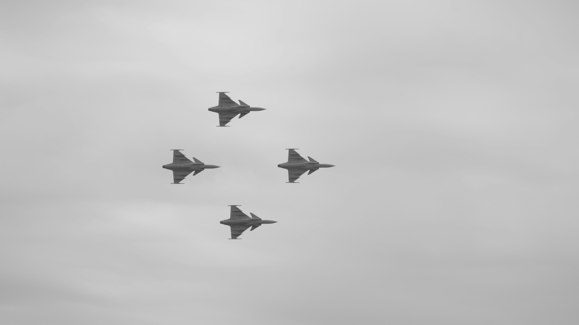 A group of fighter jets flying through a cloudy sky