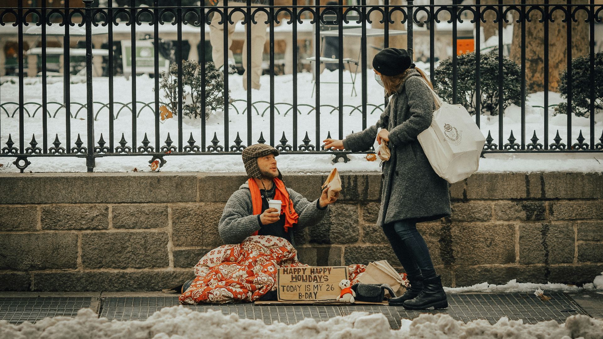 man in black jacket and black pants sitting on white snow covered ground during daytime