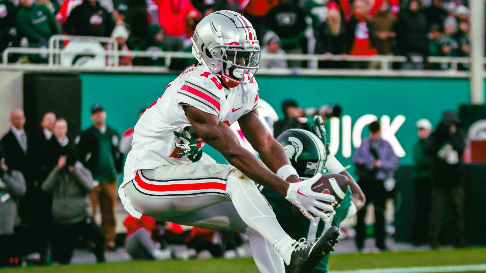 A football player running with a football on a field