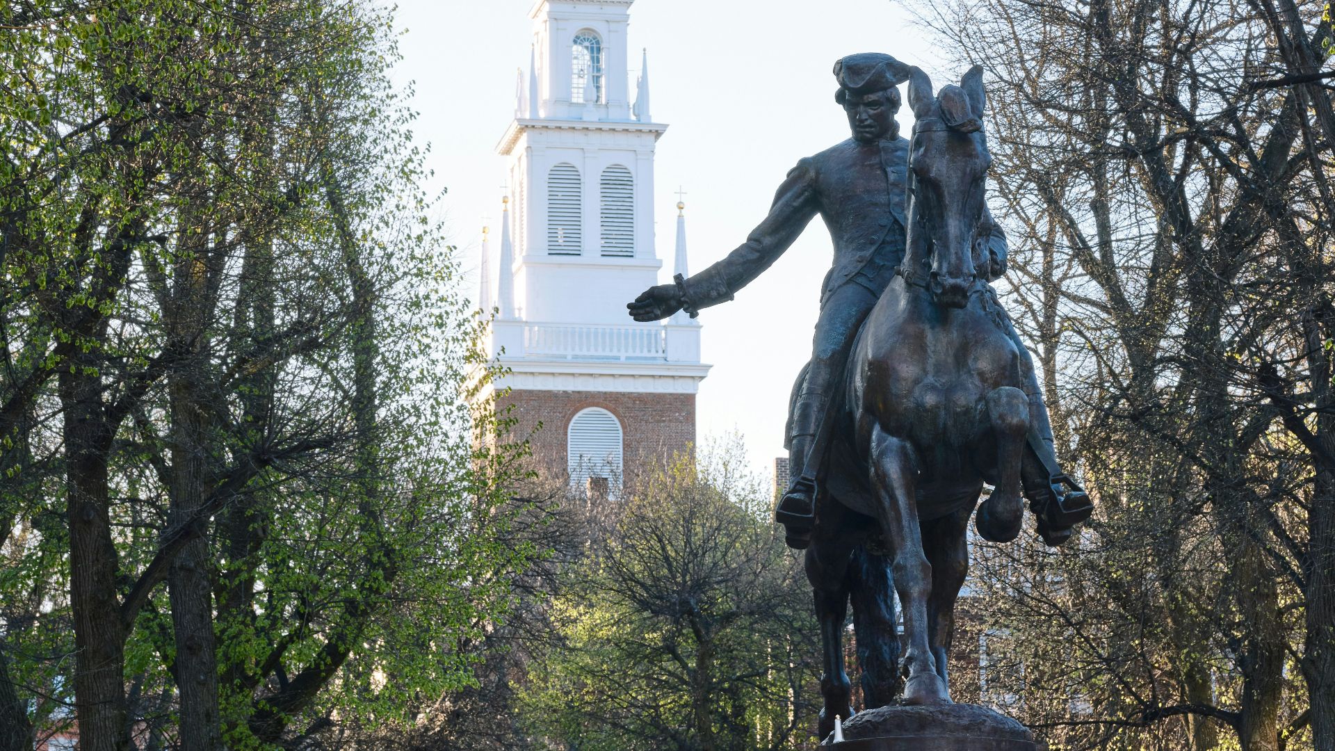 a statue of a man riding a horse in front of a church
