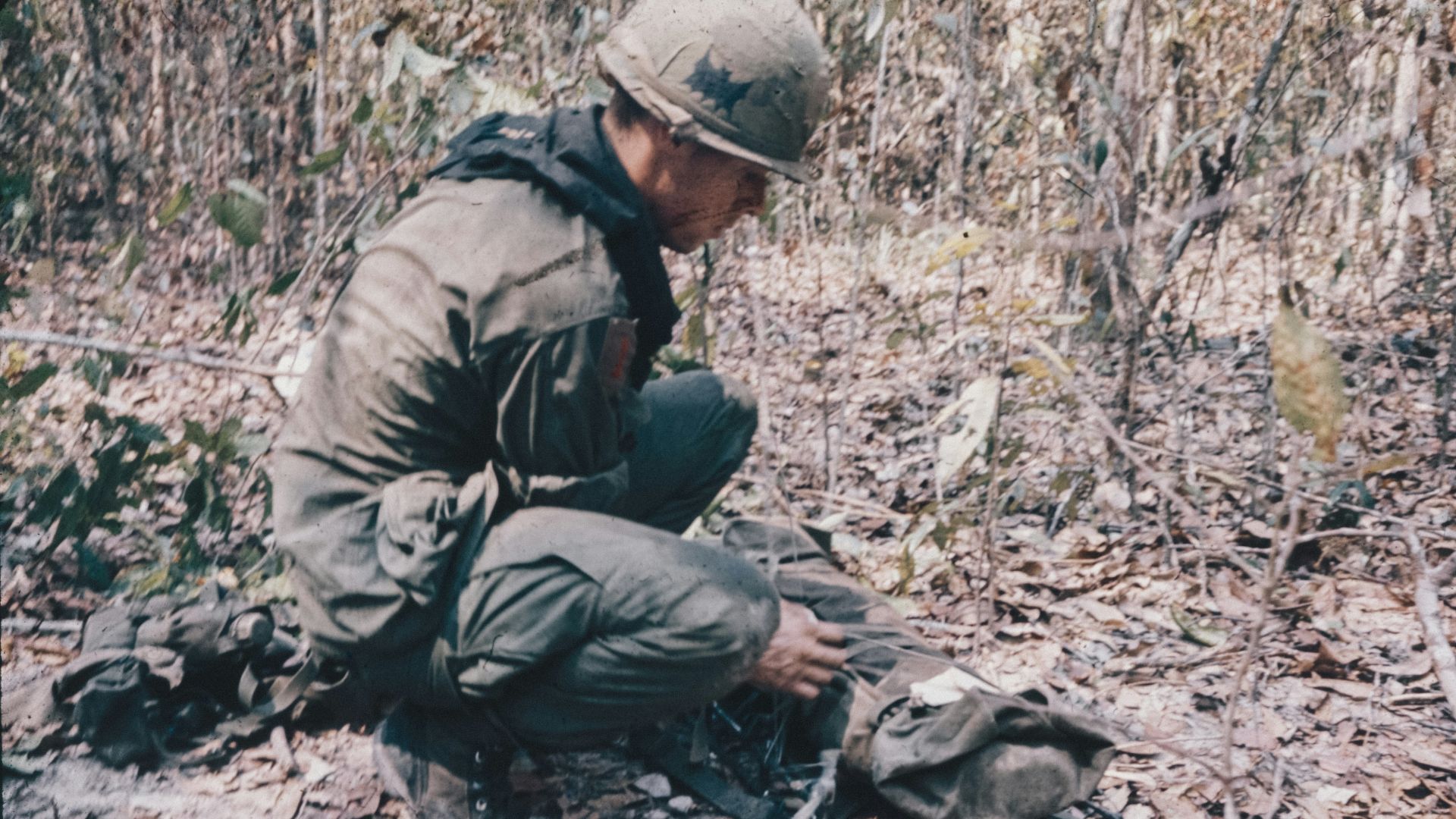 A man kneeling down next to a dead animal
