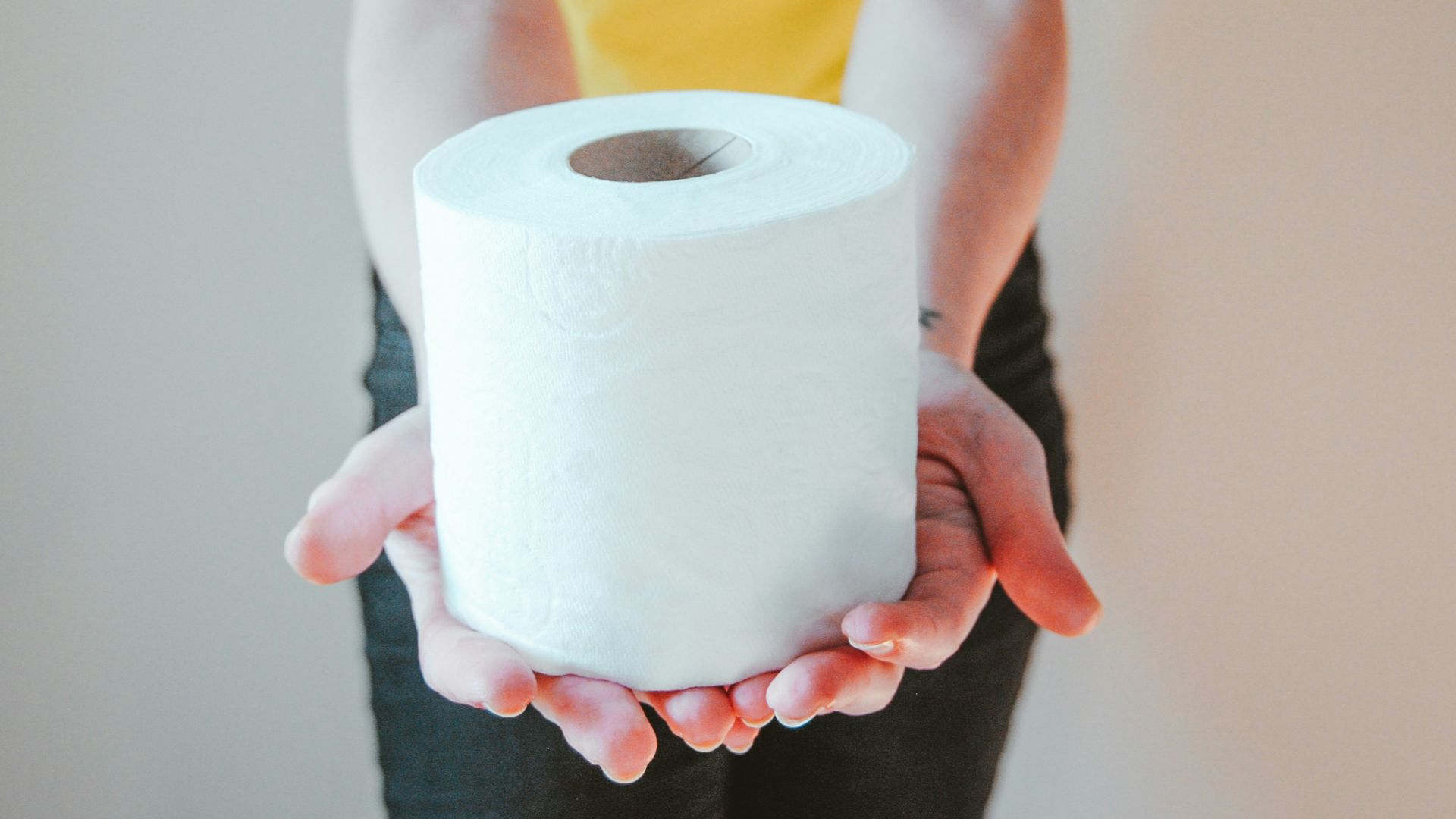 woman in yellow t-shirt holding white tissue paper