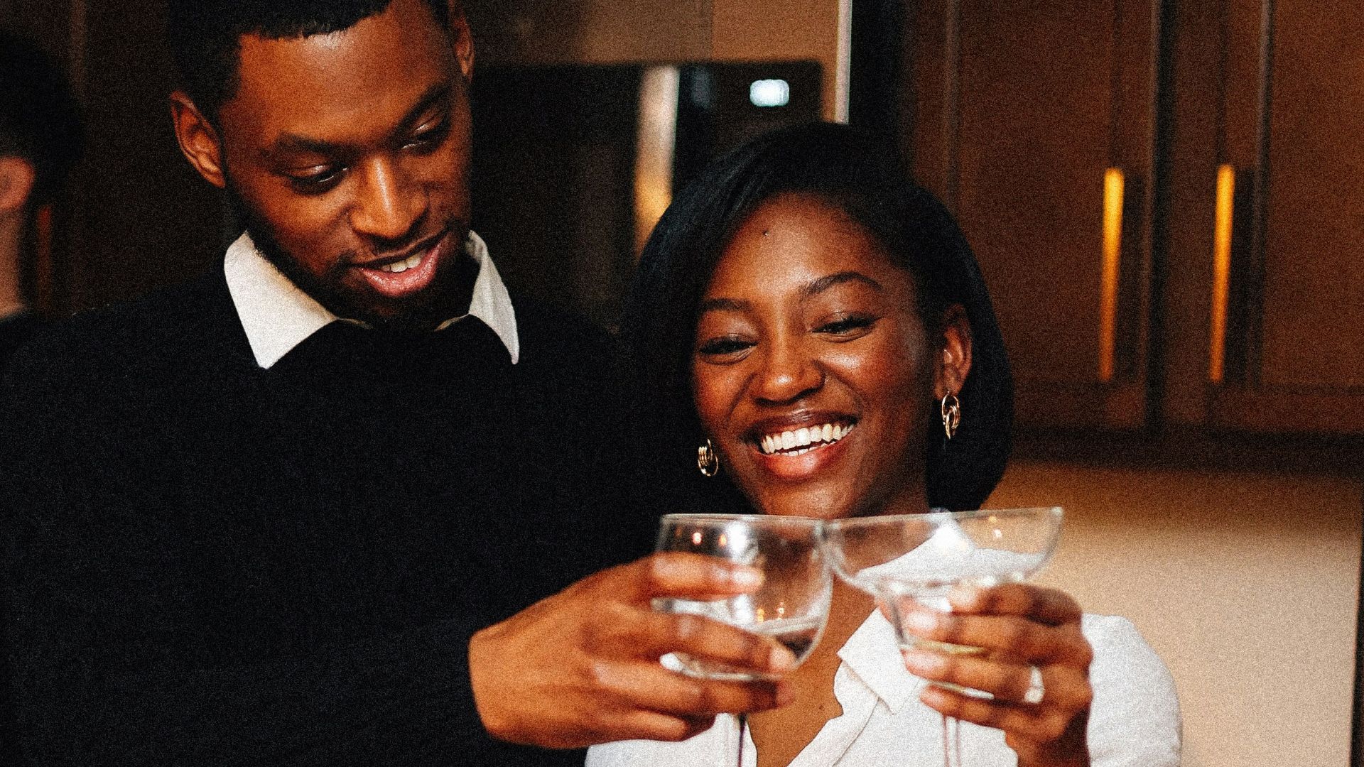 A couple is toasting with champagne flutes.