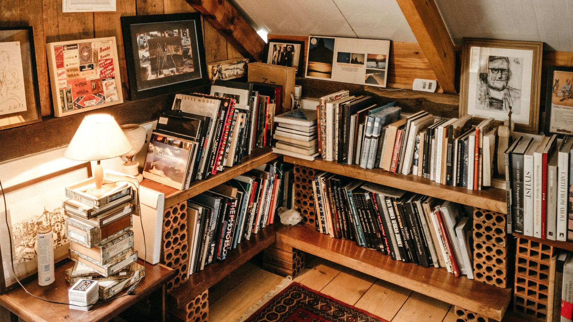 books in bookcase by turned-on table lamp