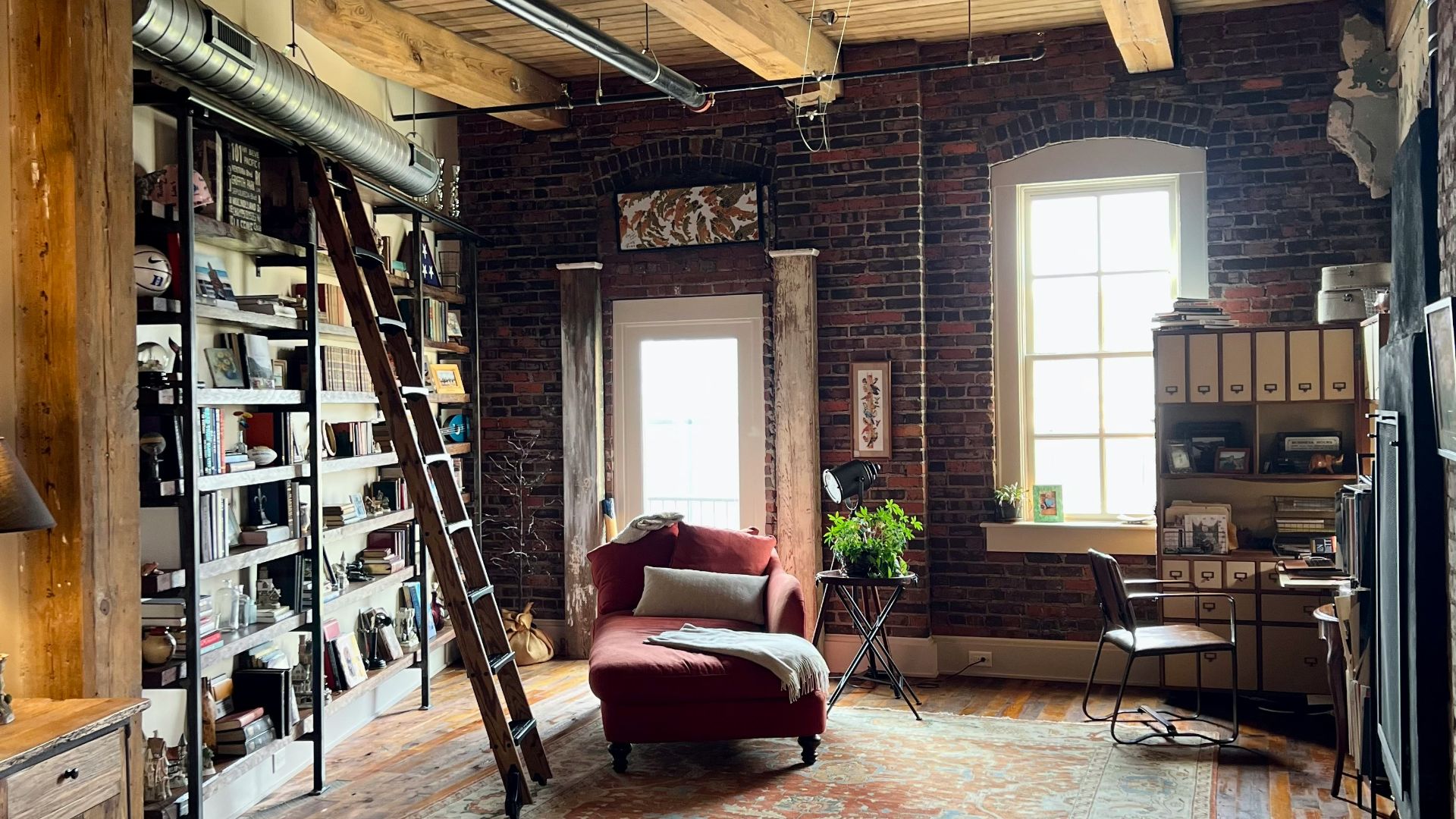 a room with a ladder and bookshelves