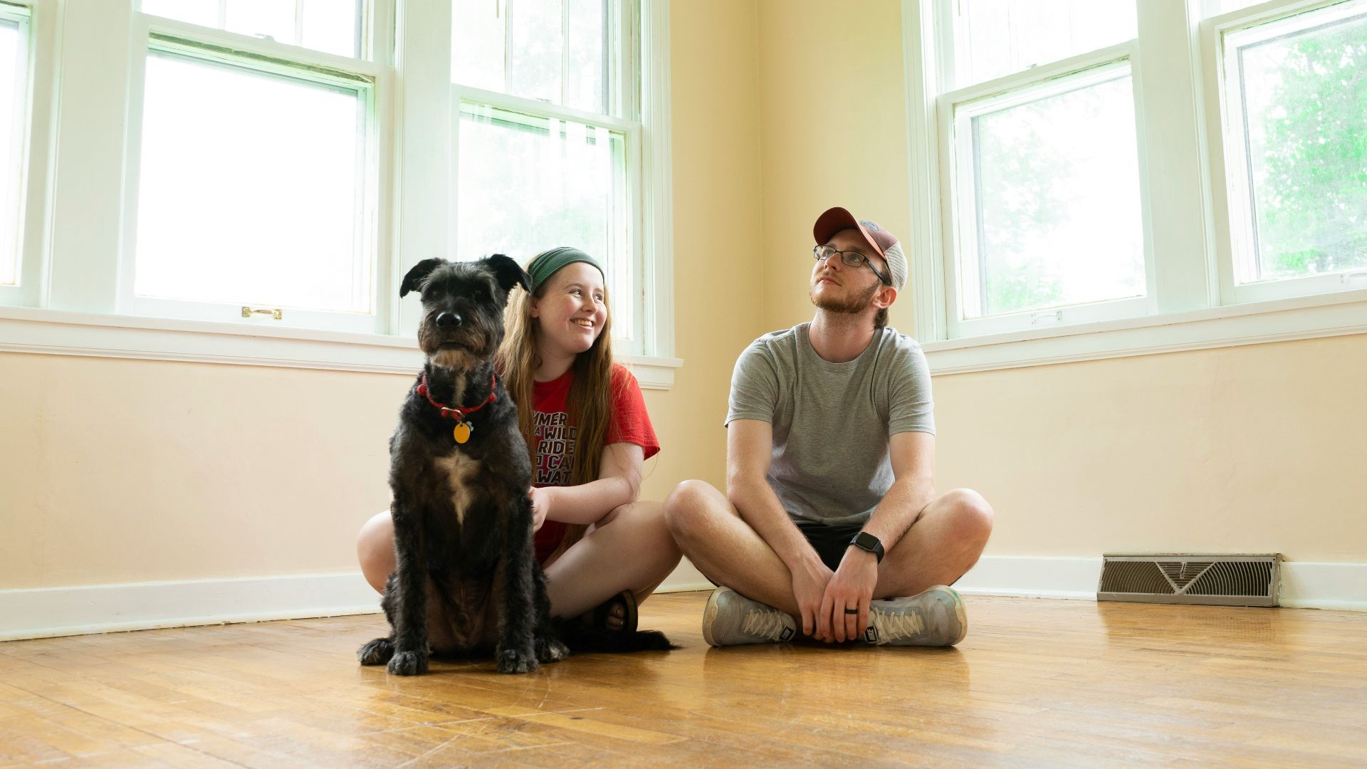 woman in gray shirt sitting on brown wooden floor