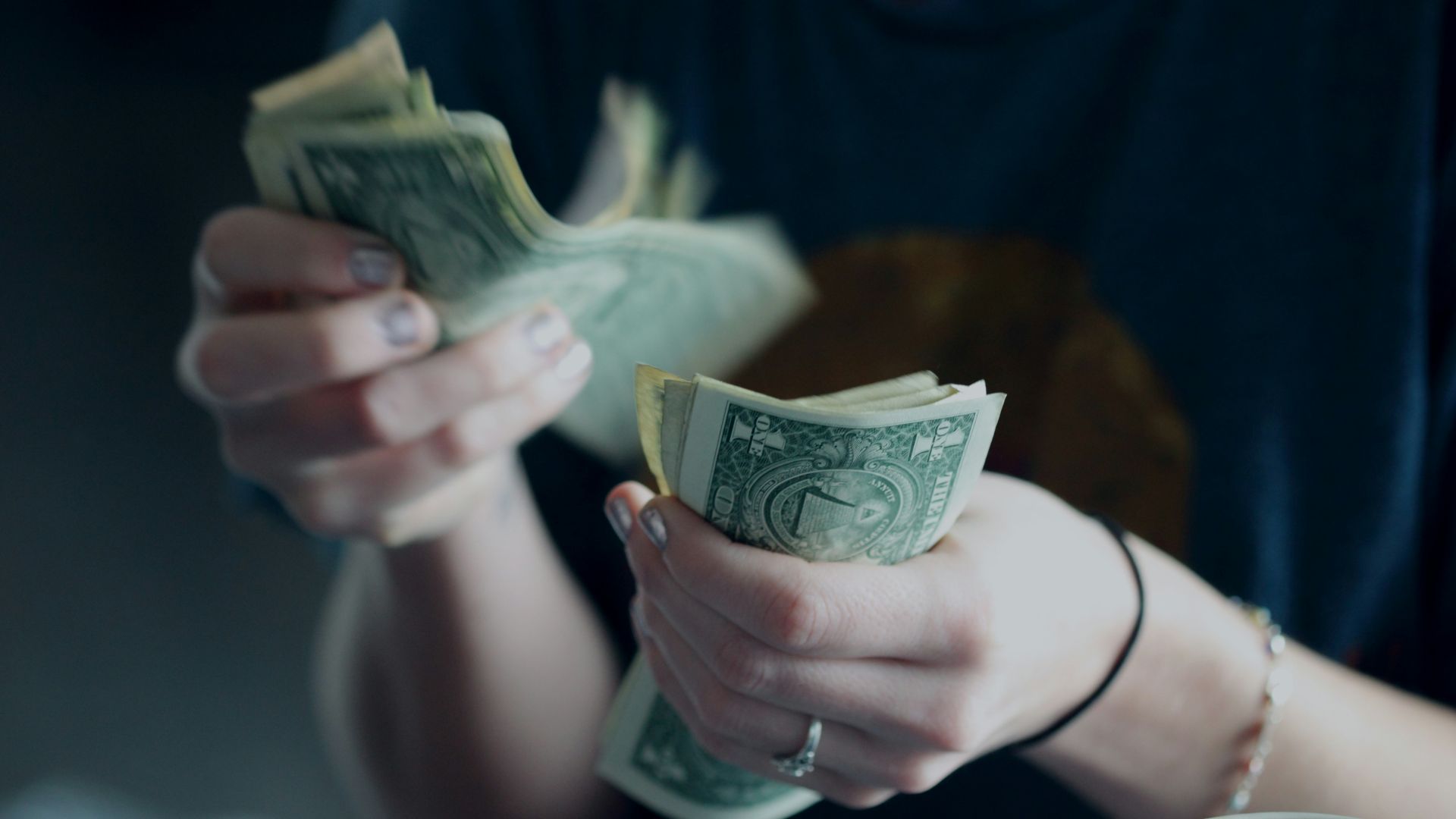 focus photography of person counting dollar banknotes