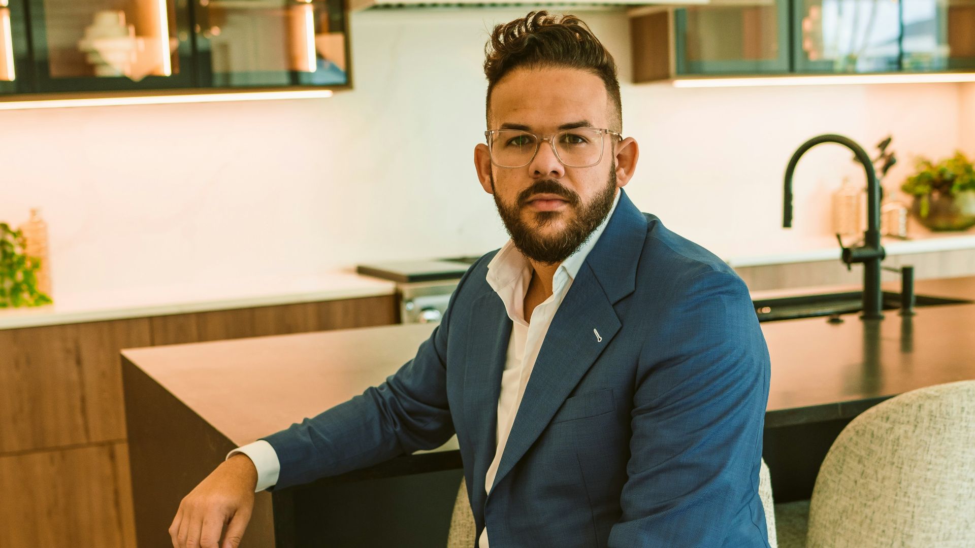 a man in a blue suit sitting on a chair