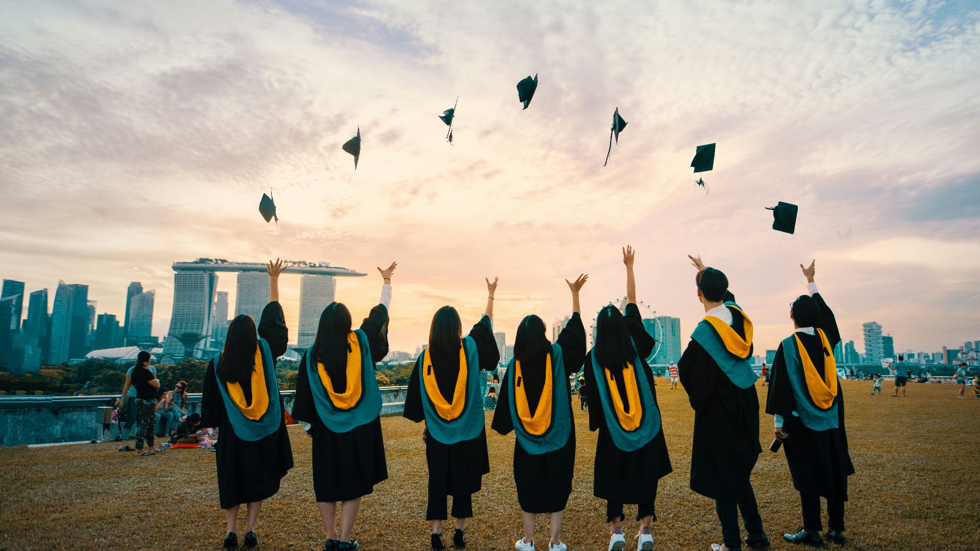 people throwing hats on air