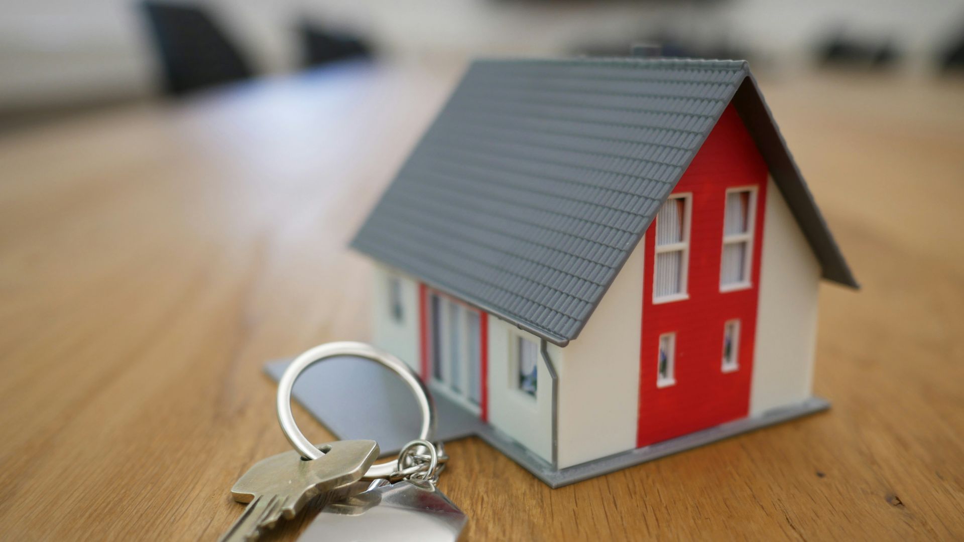 white and red wooden house miniature on brown table