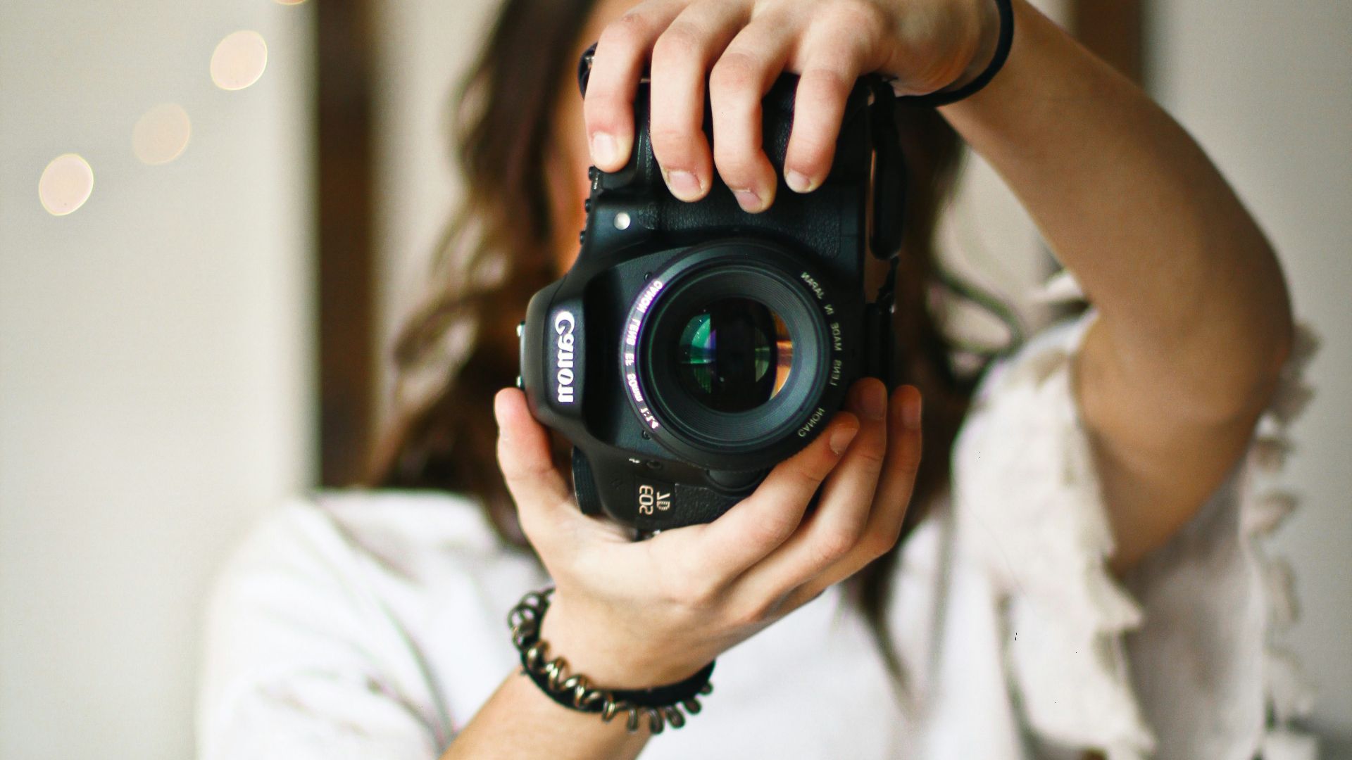 woman holding black DSLR camera