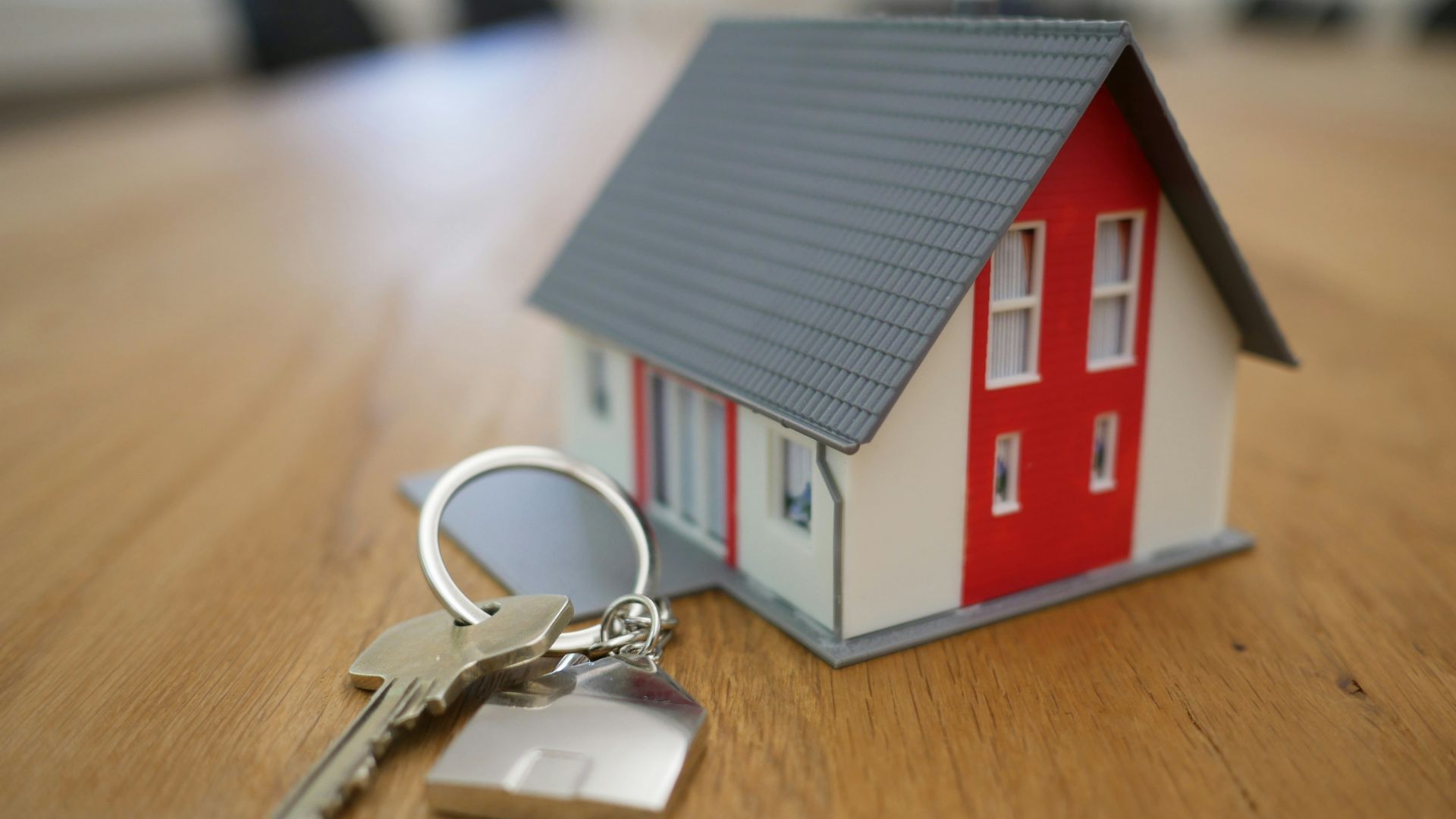 white and red wooden house miniature on brown table