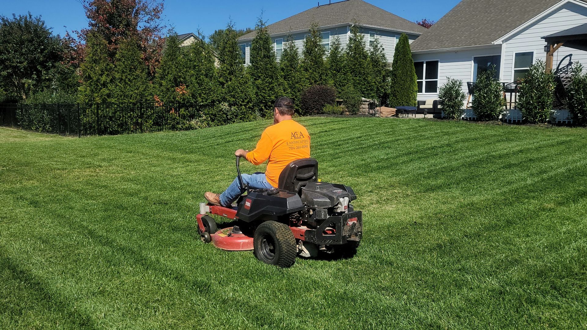 A man riding on the back of a lawn mower