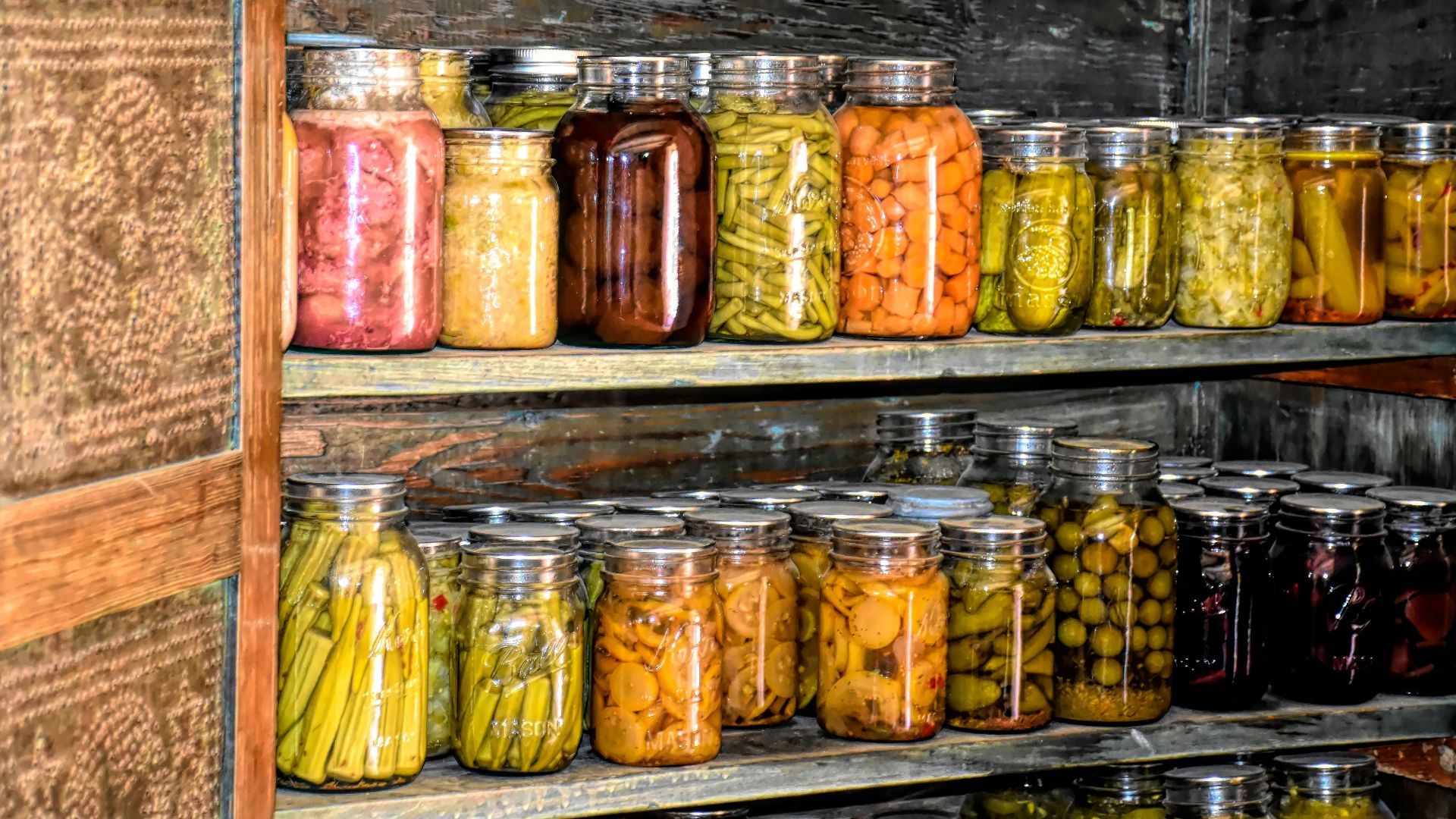 a wooden shelf filled with lots of jars of food