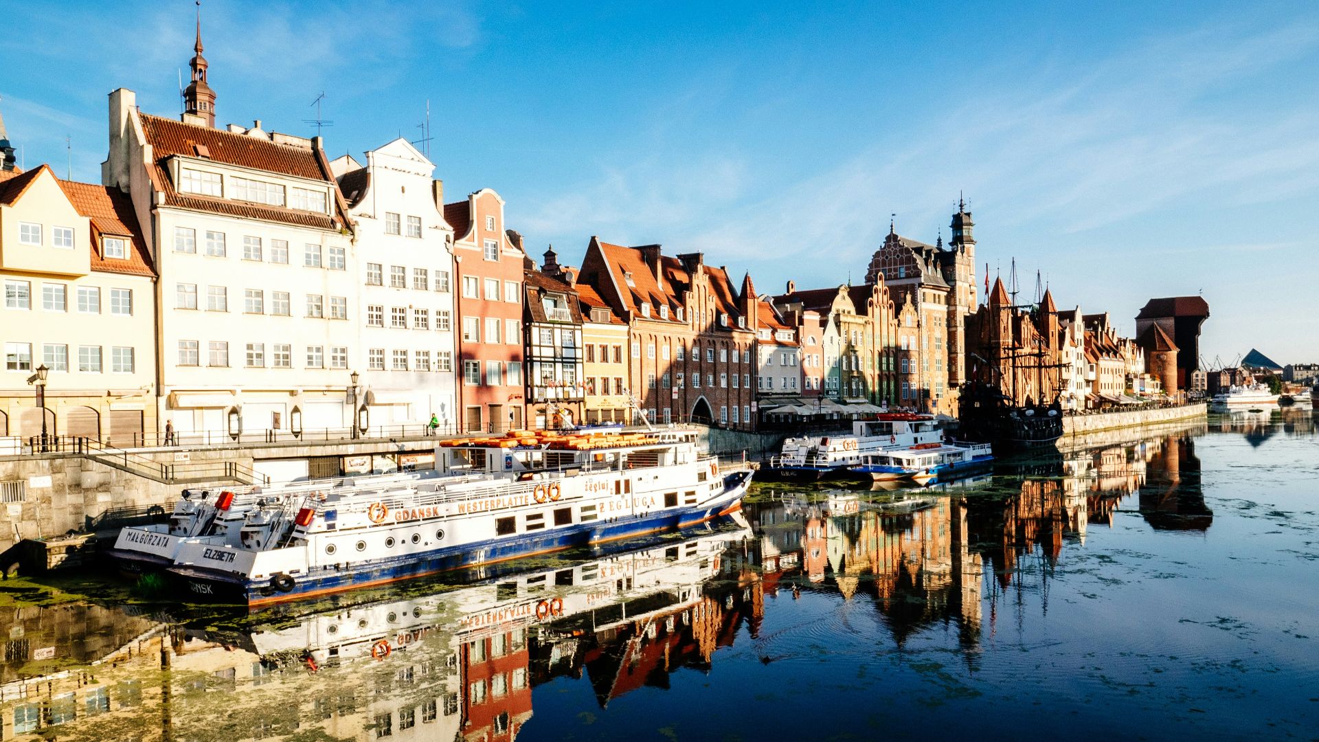 white and blue boat docked near buildings