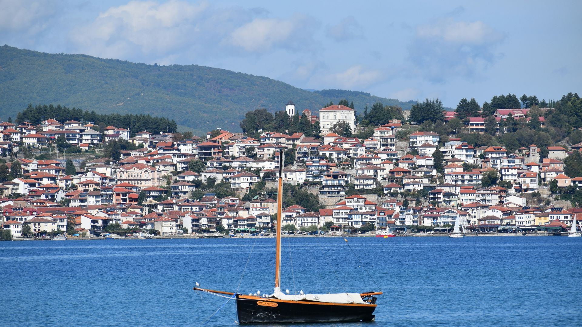 brown boat on body of water near city buildings during daytime