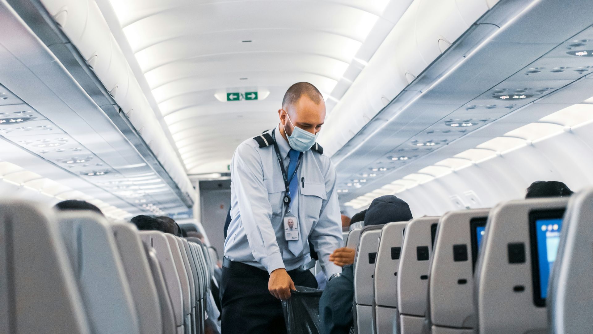 man in blue dress shirt standing in airplane