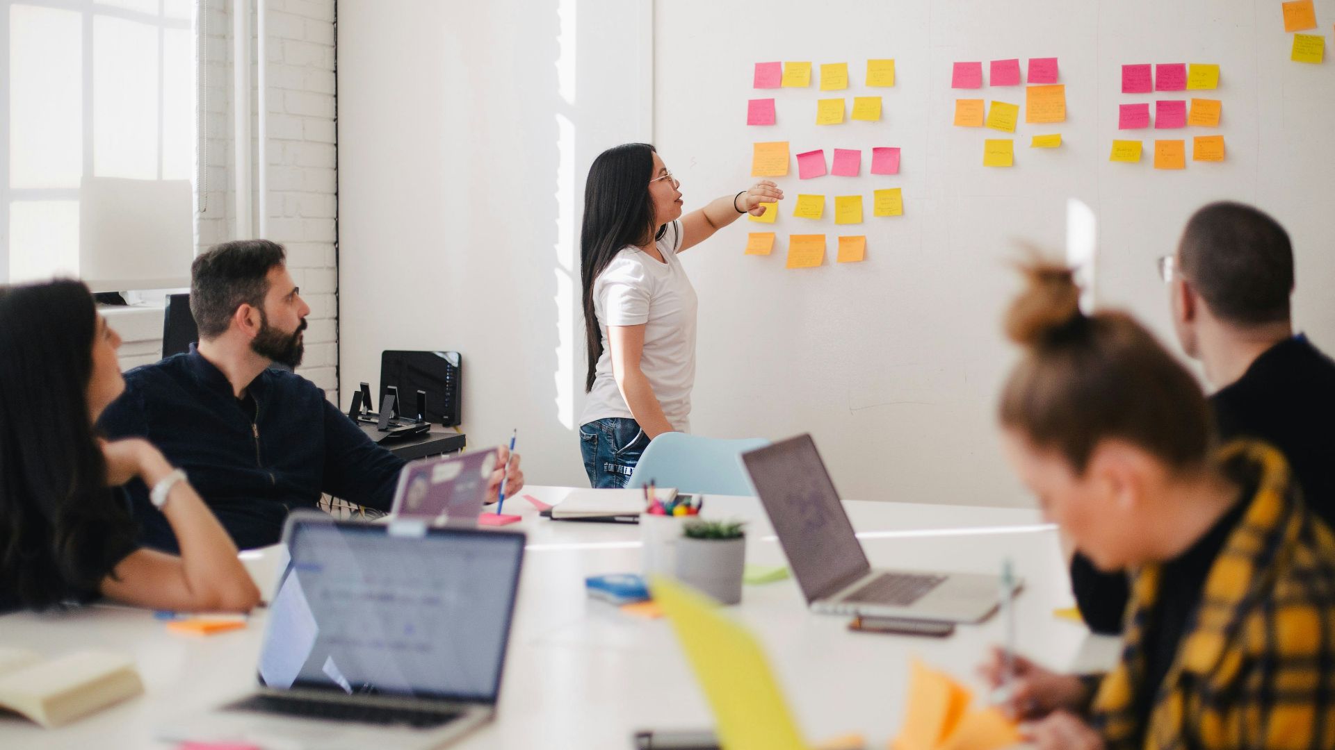 woman placing sticky notes on wall