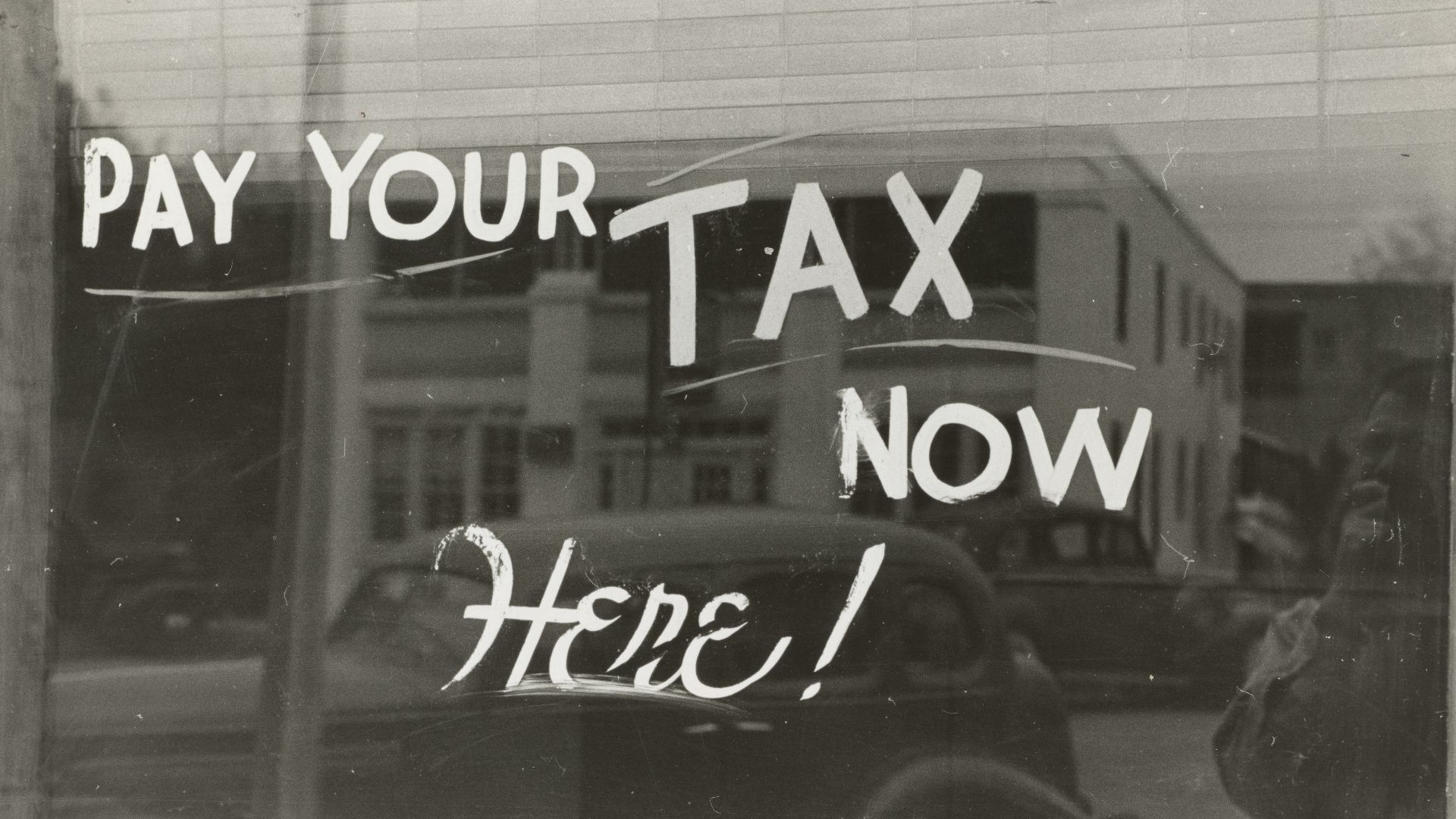 a sign that says pay your tax now here