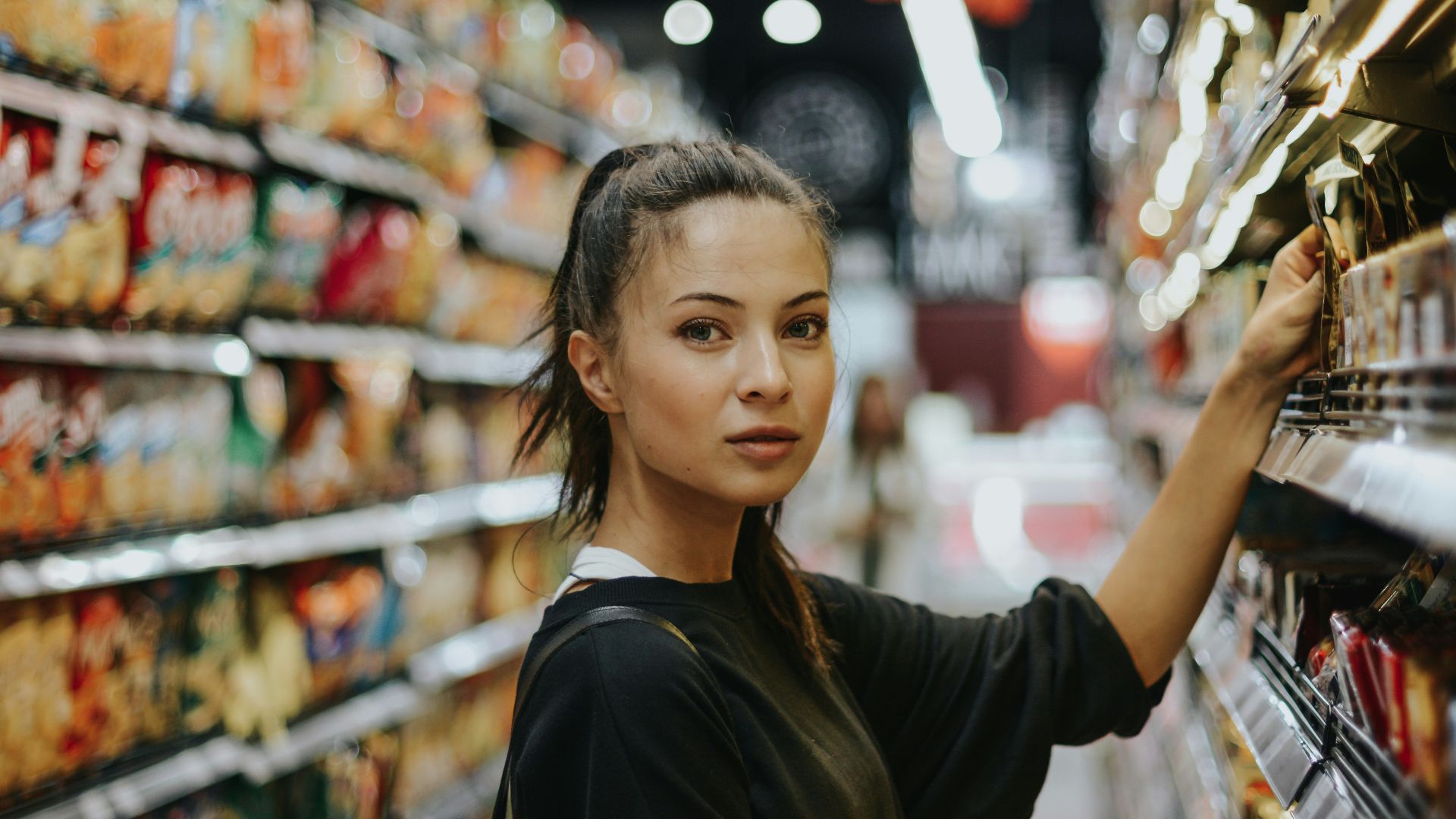 woman selecting packed food on gondola