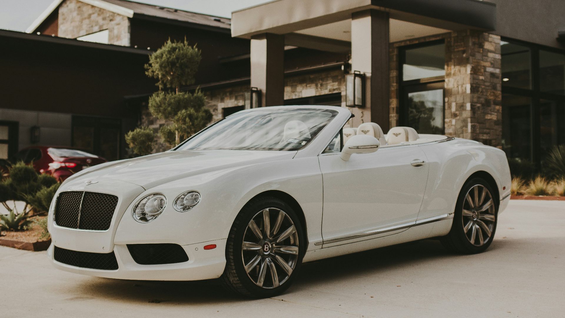 white porsche 911 parked in front of building