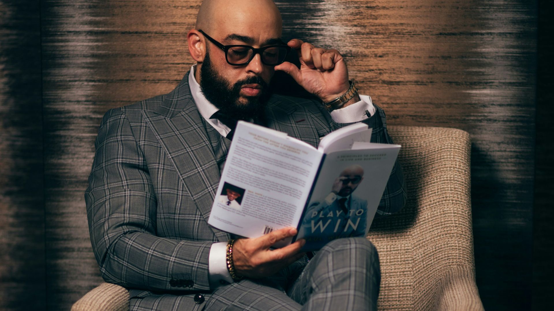 woman in gray blazer sitting on brown sofa chair