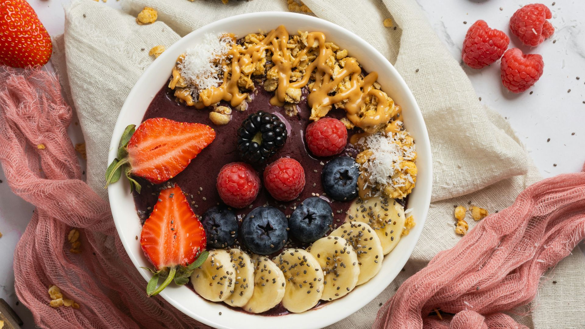 a bowl of cereal with berries, bananas, and other fruits