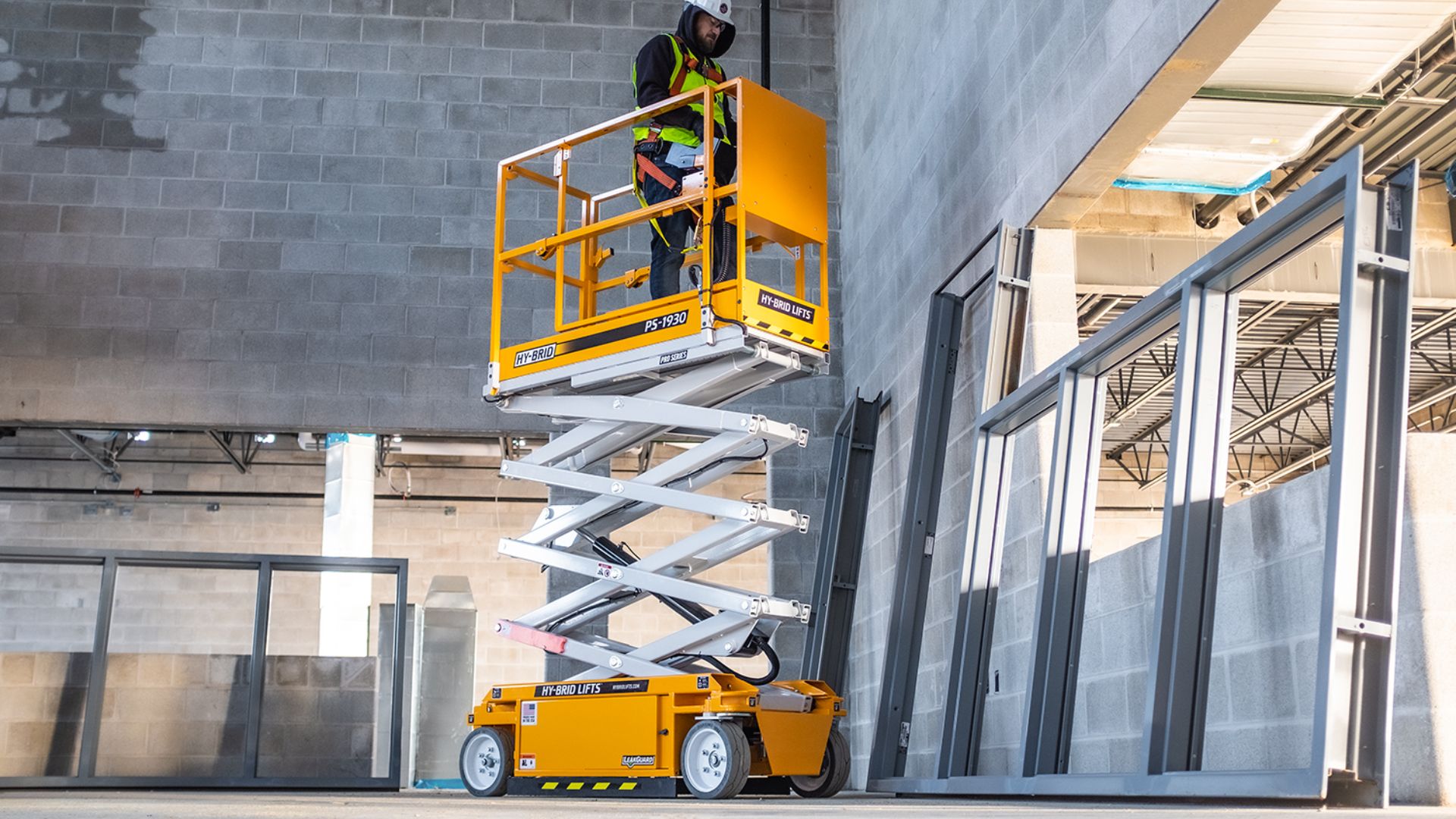 File:Hy-Brid Lifts PS-1930 scissor lift with worker working while elevated.jpg