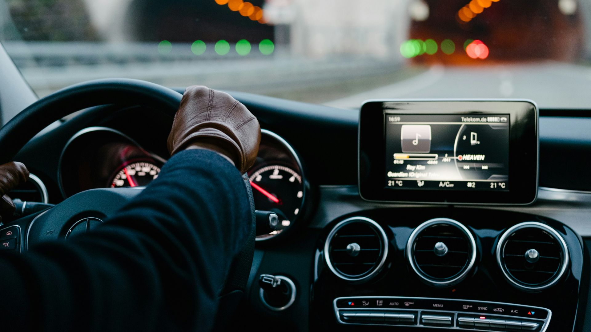 person inside vehicle holding steering wheel