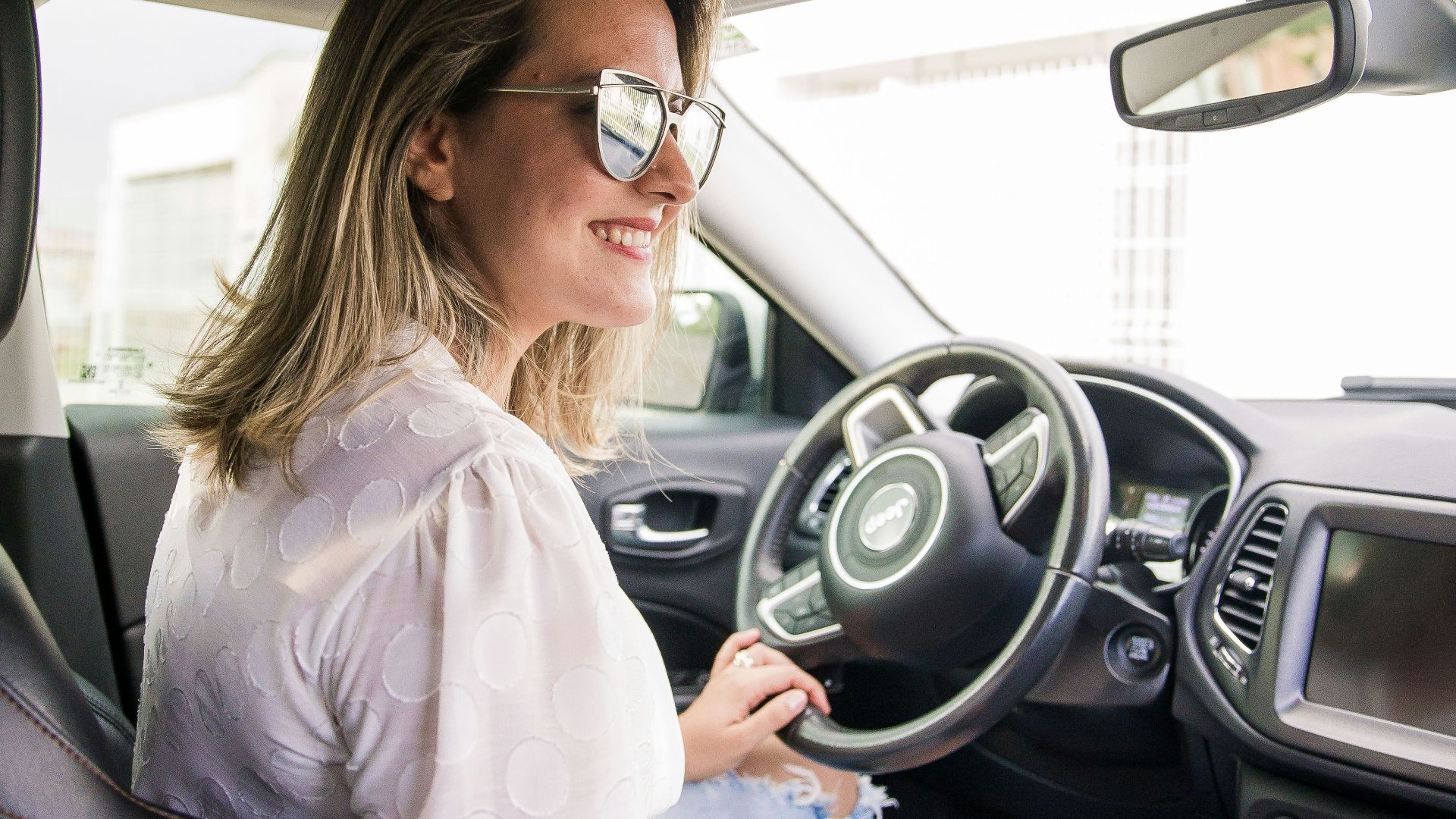 woman in white long sleeve shirt driving car