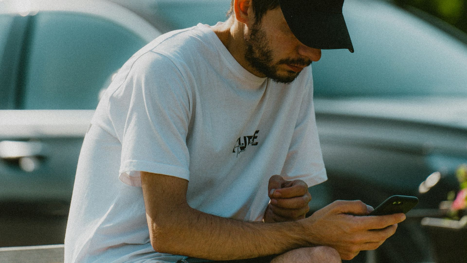 a man sitting on a bench looking at his cell phone