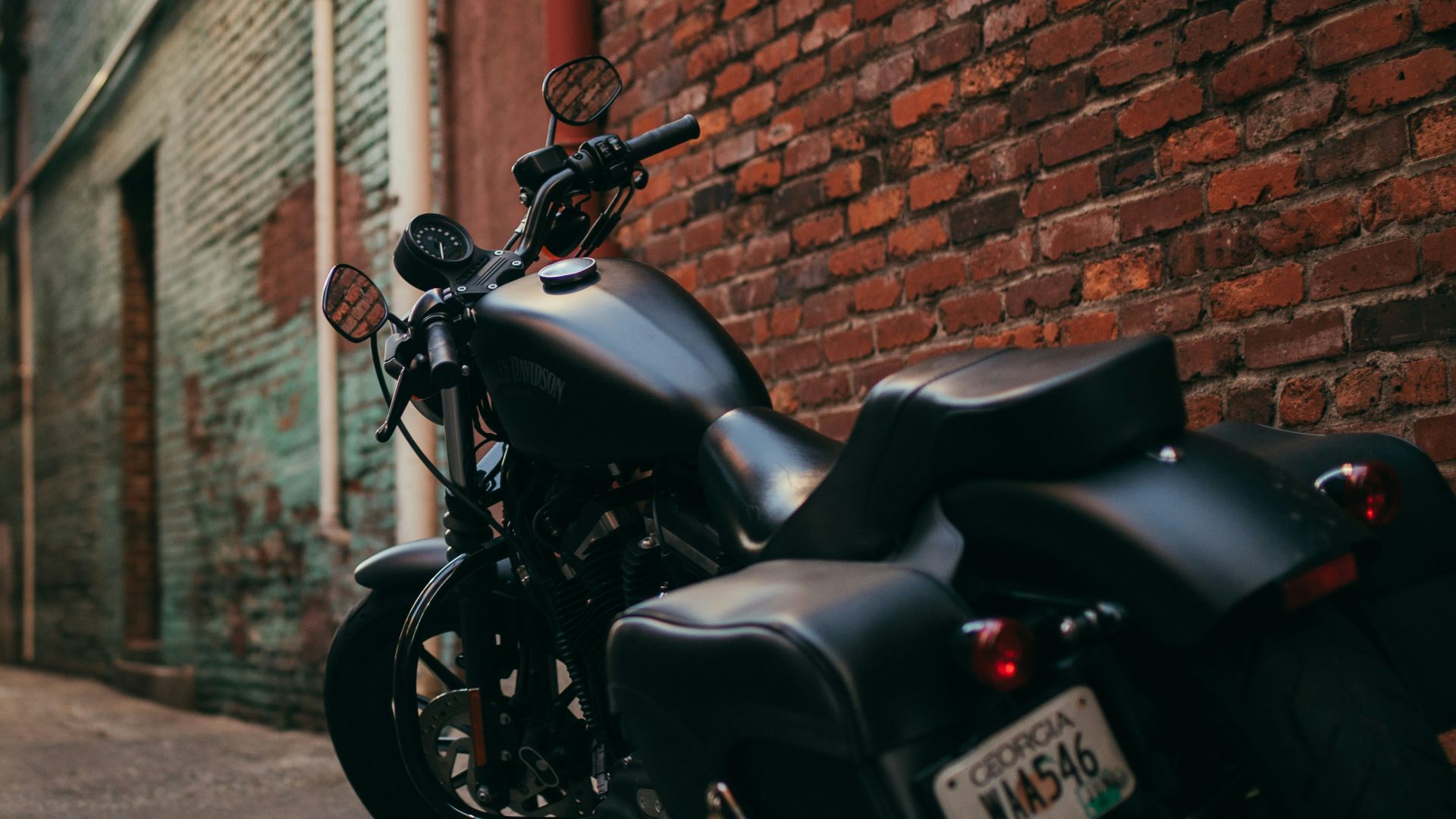 black cruiser motorcycle parked at the middle of the alley