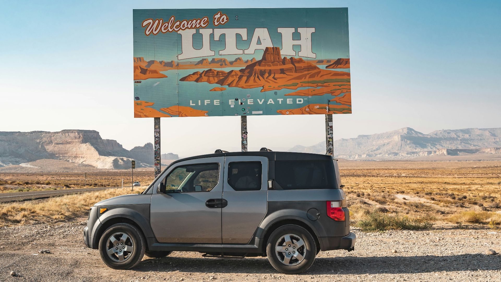 gray suv parked near white and blue signage during daytime