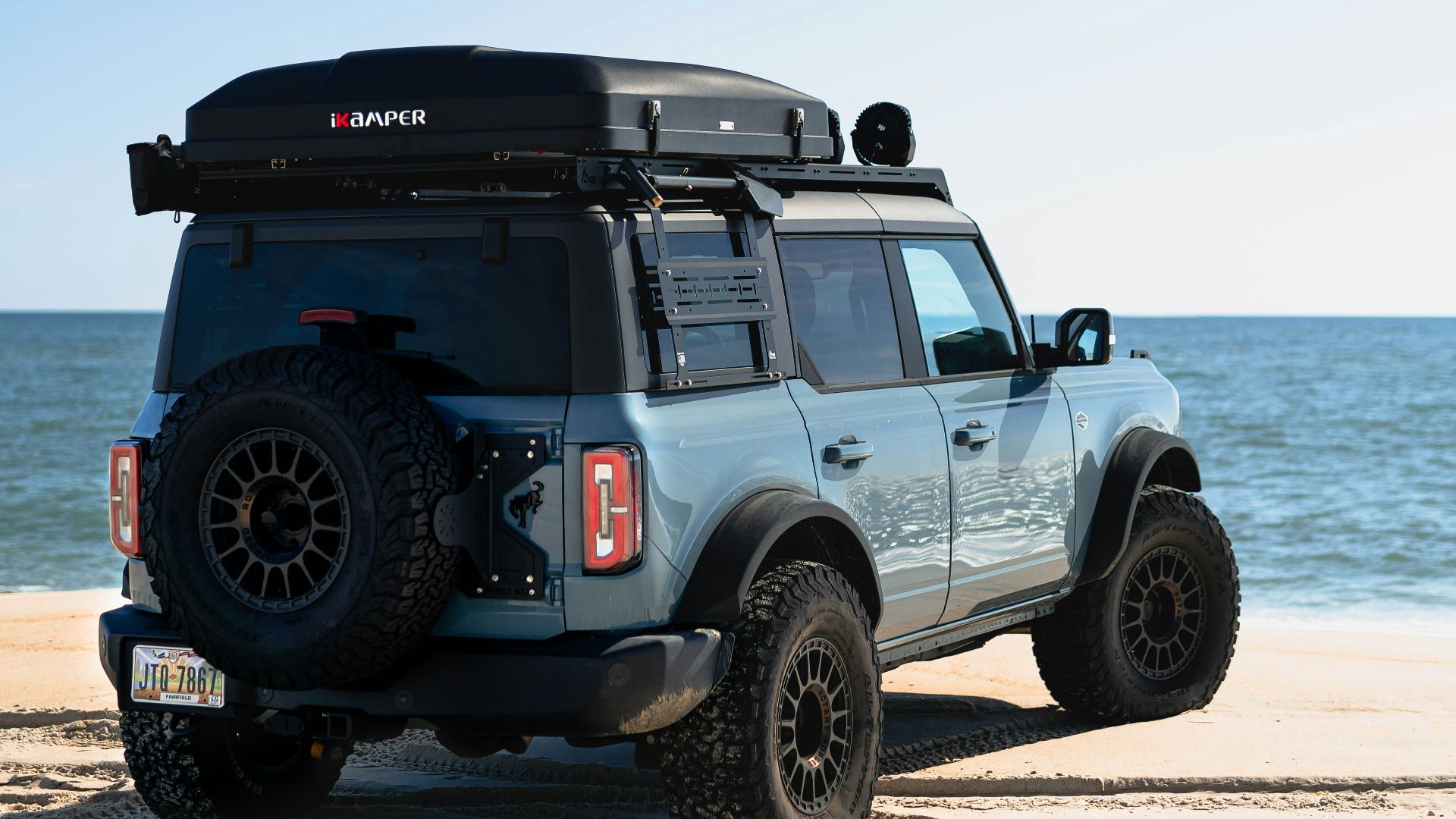 a jeep parked on a beach near the ocean
