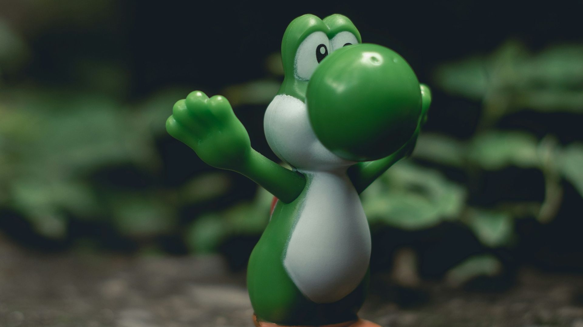 green frog figurine on black and brown surface