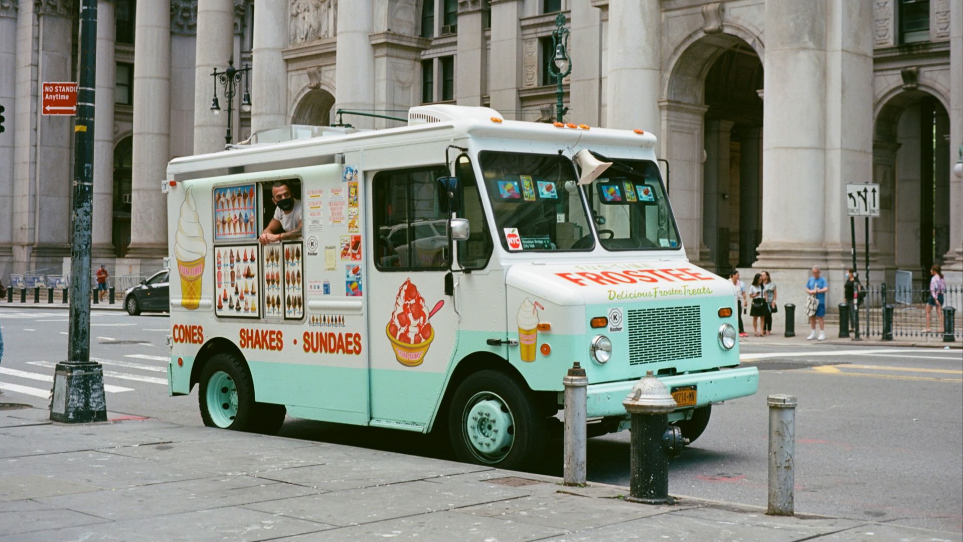 white and green van parked beside building during daytime